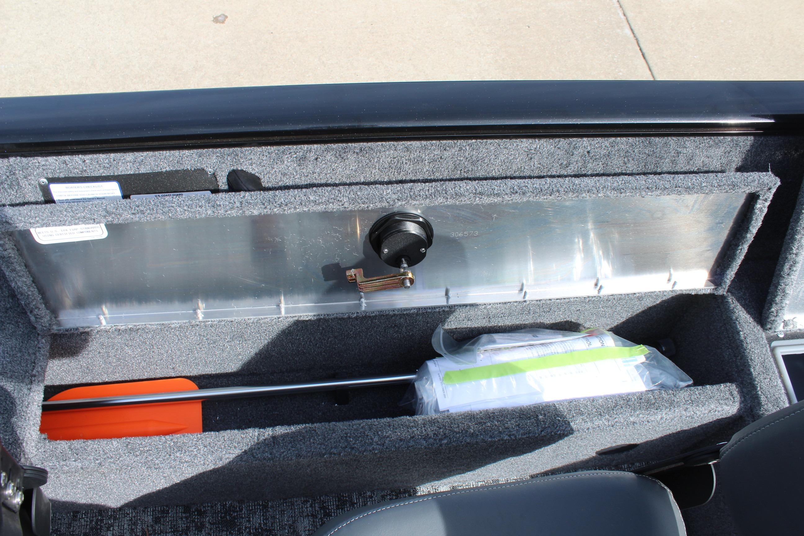 Storage compartment in 2026 Tracker Pro Guide V-16 WT boat, featuring safety equipment and accessories.