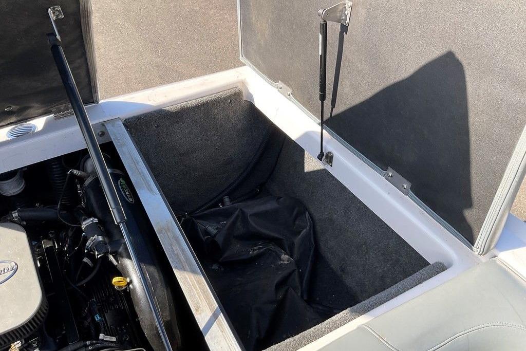 2015 Moomba Outback V engine compartment with open storage area and hydraulic lift supports.
