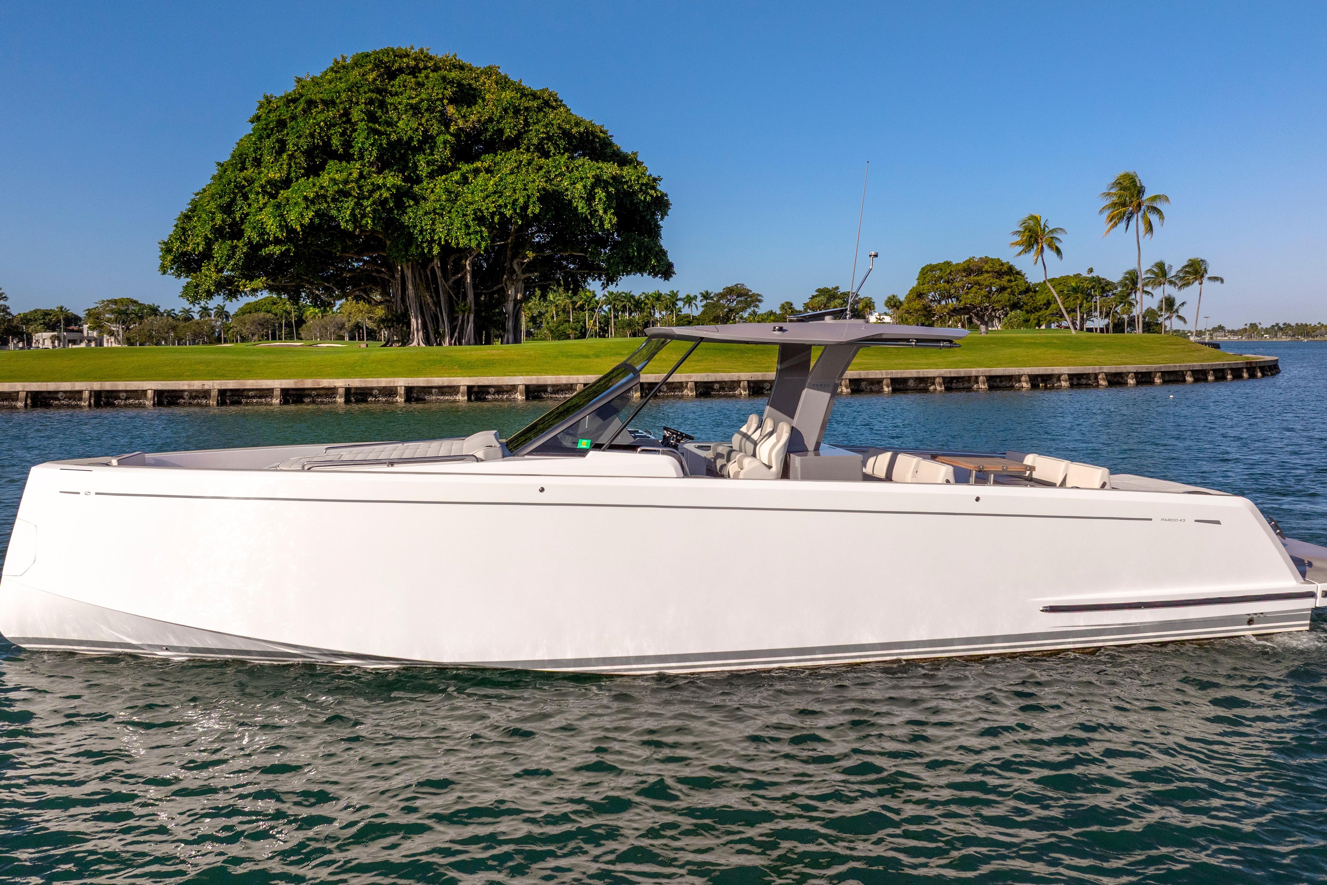 2024 Pardo Yachts P43 luxury yacht cruising on a sunny day near lush greenery.