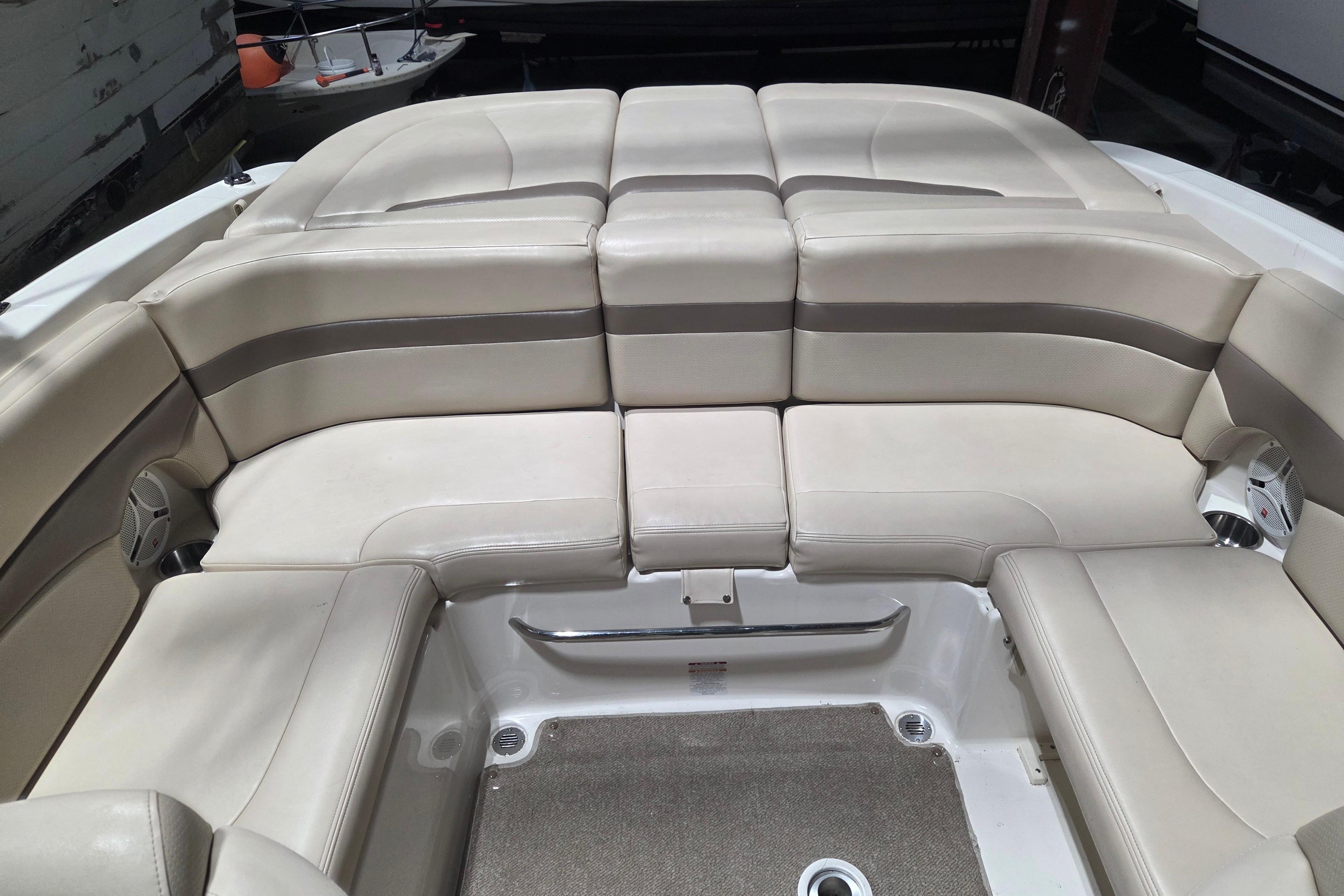 2006 Chaparral 236 SSi boat interior with beige cushioned seating and carpeted floor.