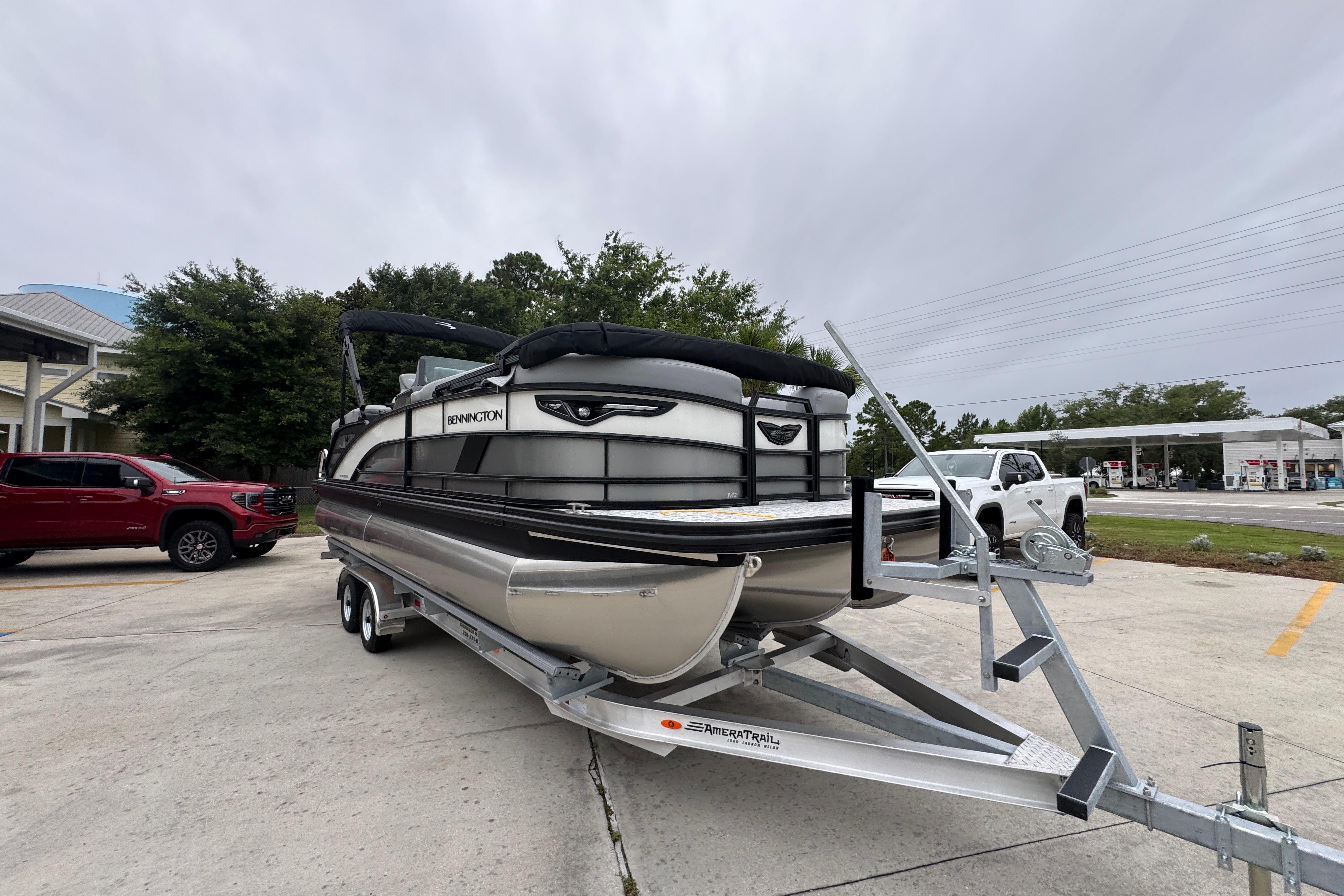 2027 Bennington 24 MFB pontoon boat on trailer in parking lot.