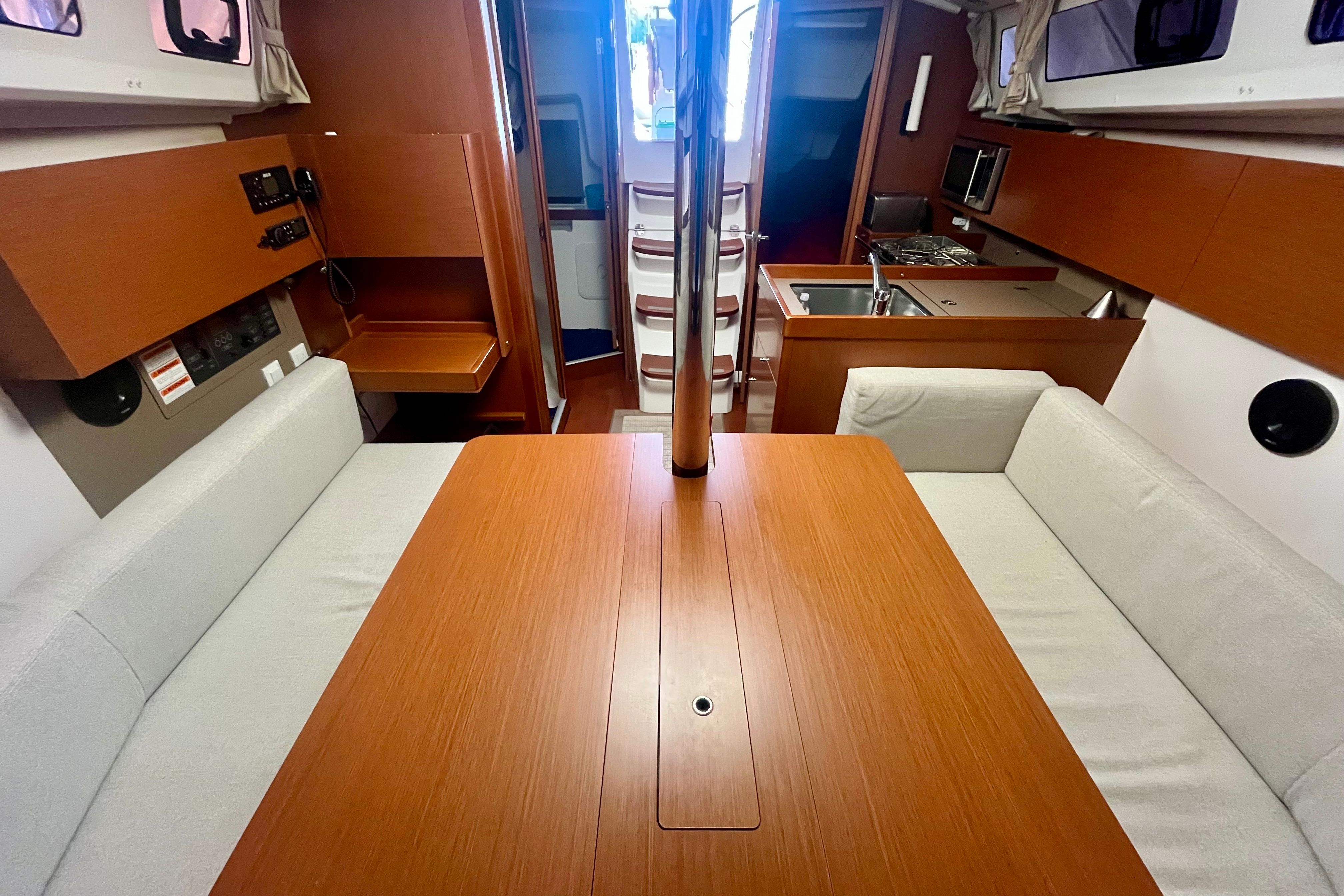 Interior of 2019 Beneteau Oceanis 35.1 yacht, featuring a cozy dining area and modern kitchen.