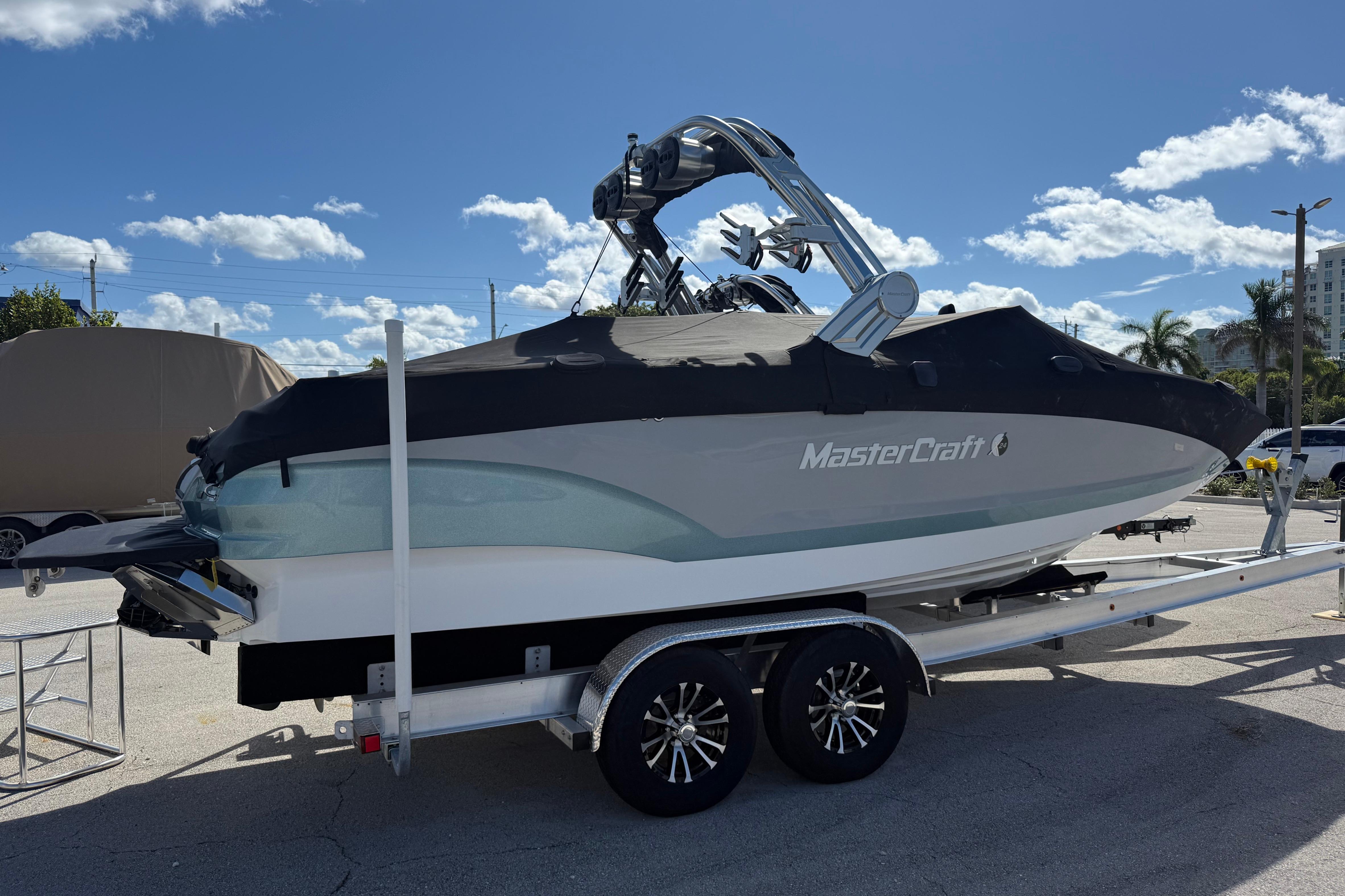 2023 MasterCraft X24 boat on trailer under clear blue sky.