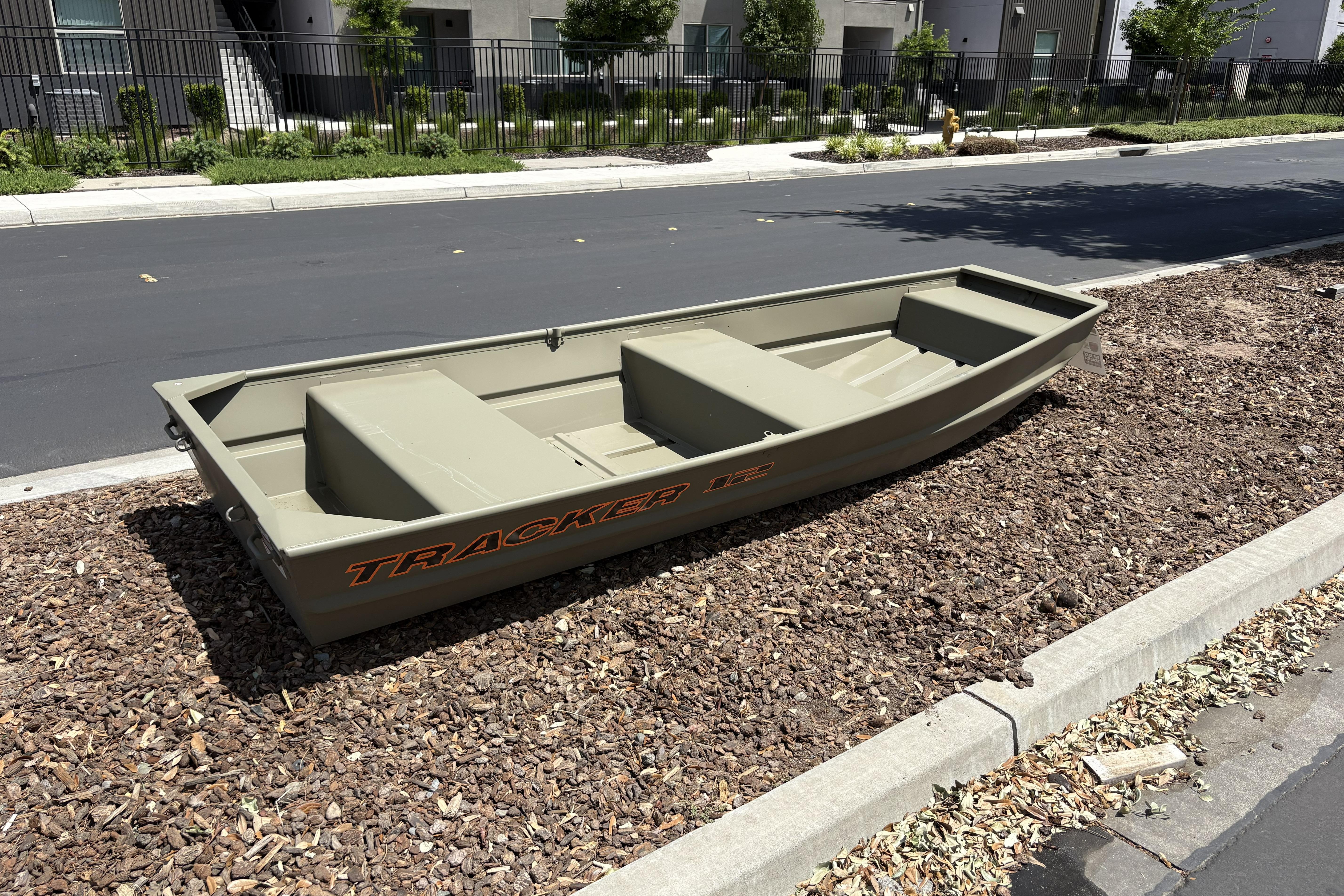 2026 Tracker Grizzly 12 Jon boat on mulch near a road.