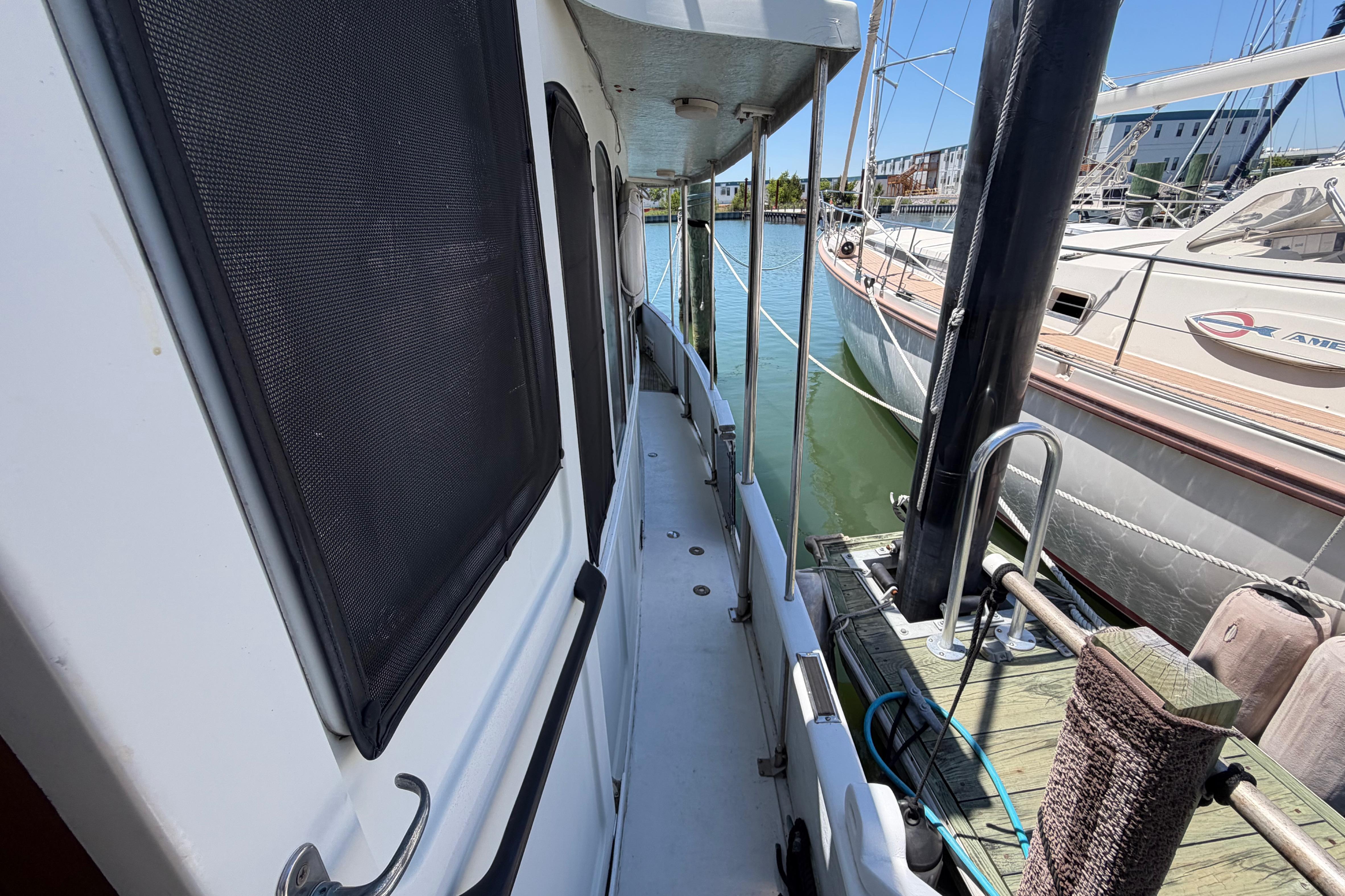 Side deck view of 1985 Gozzard PILGRIM yacht docked at marina.