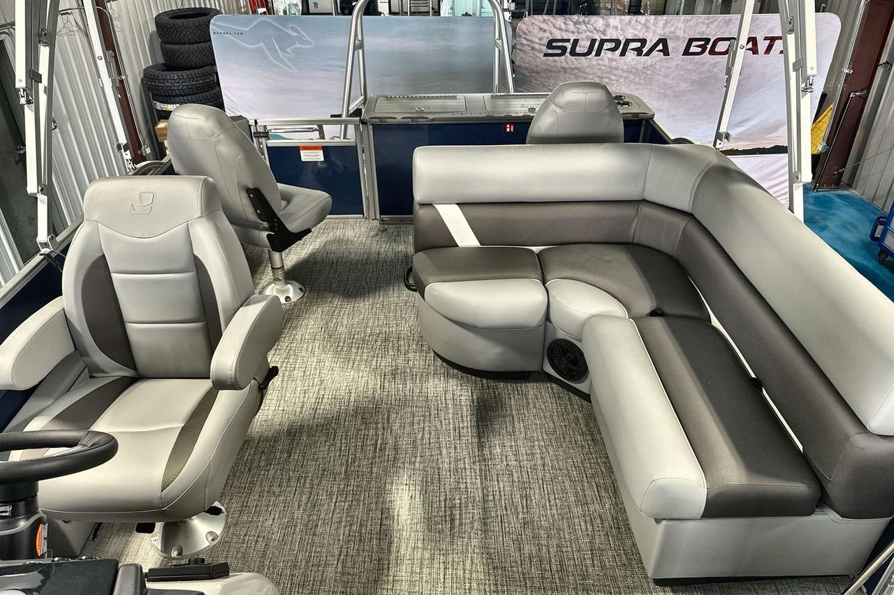 2026 Landau Island Breeze 23F pontoon boat interior with gray seating and steering console.