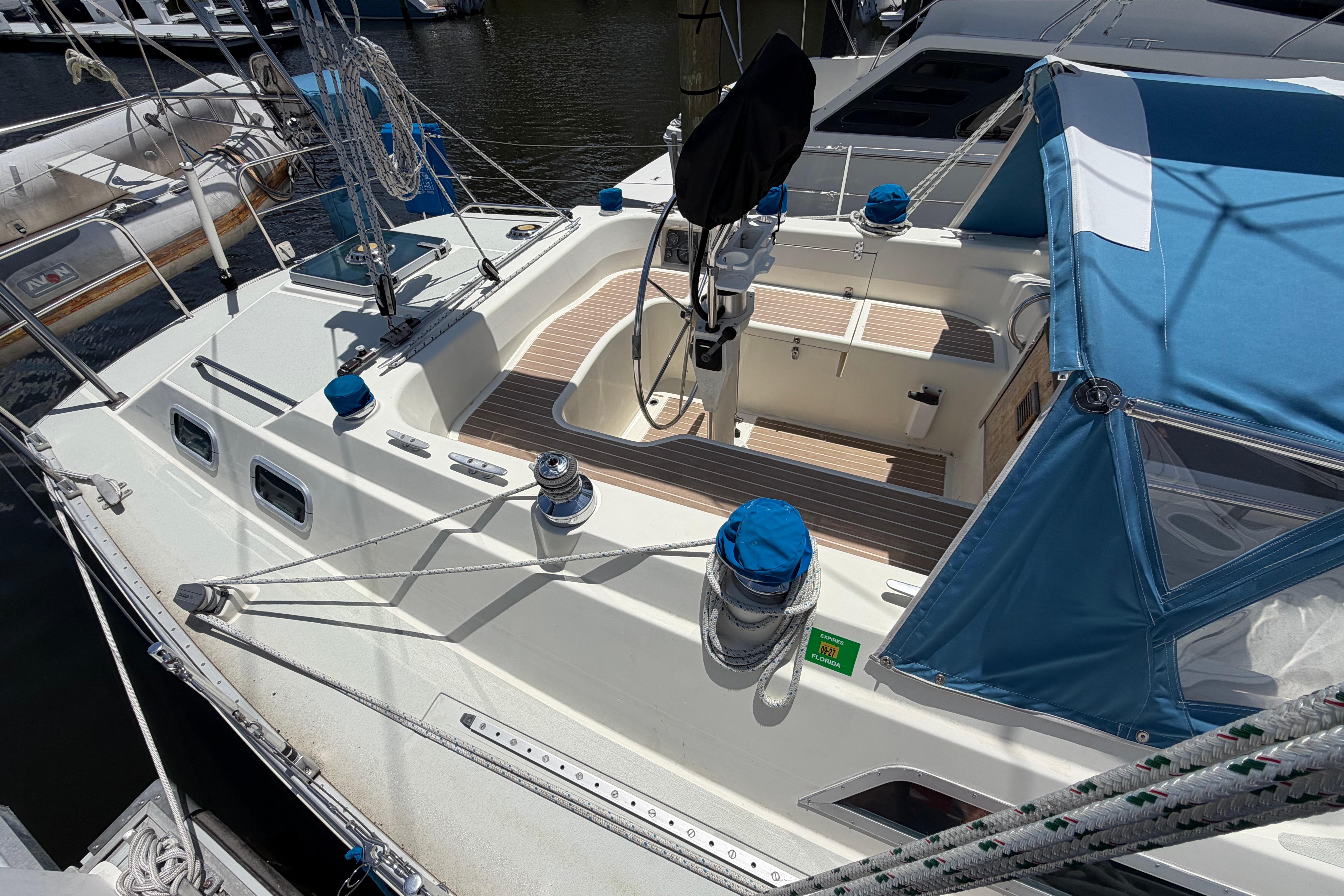 1987 Moody 376 sailboat with blue canopy, docked at marina.