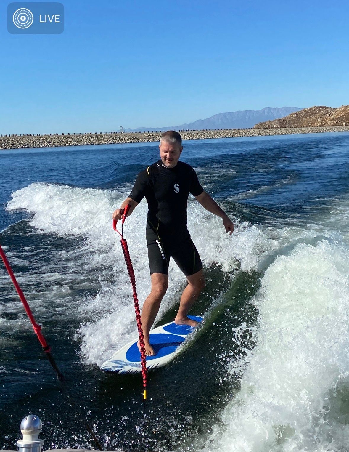 Man surfing behind a 2007 MasterCraft X-2 boat on a wave.