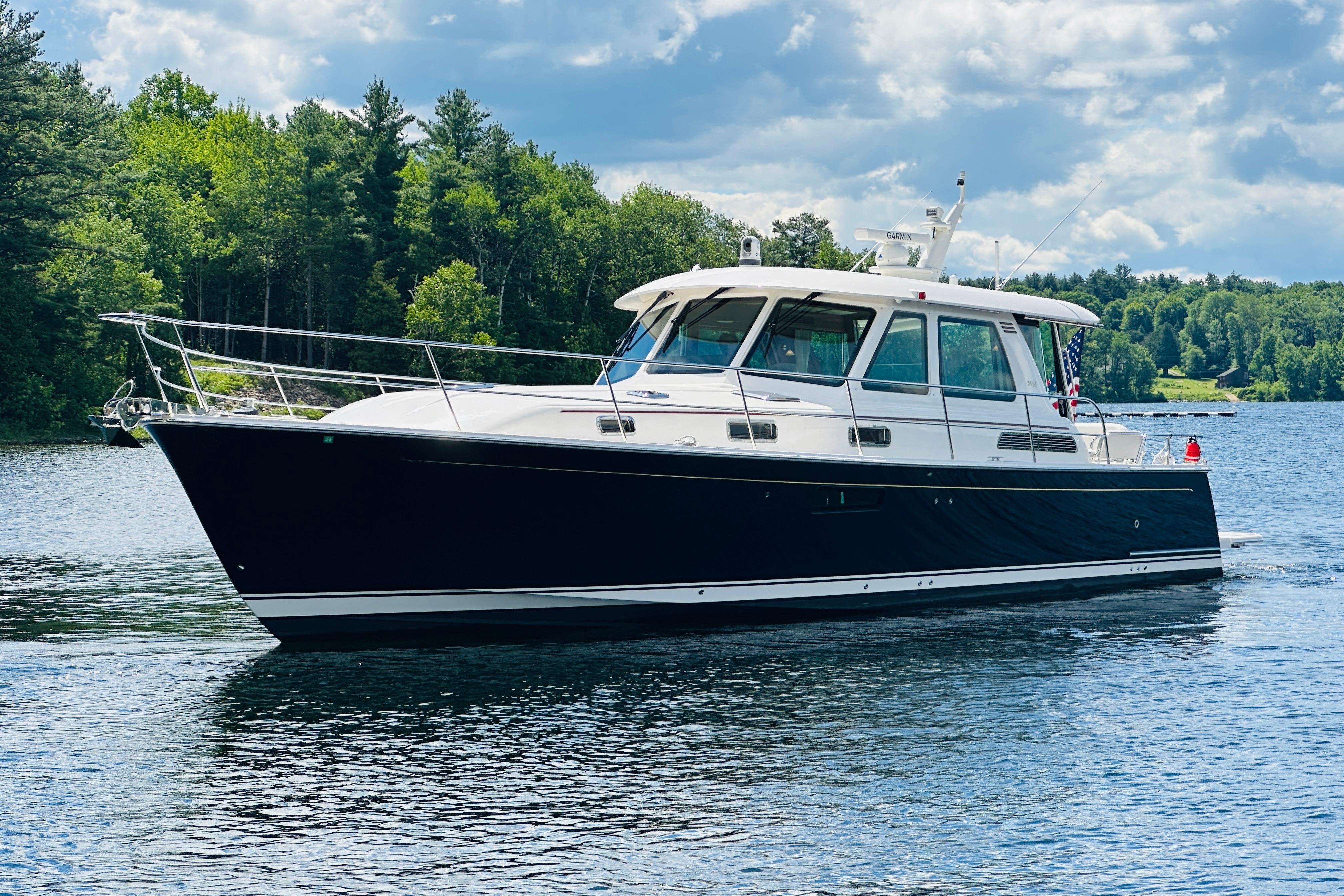 2025 Sabre 48 Salon Express yacht cruising on a scenic lake.