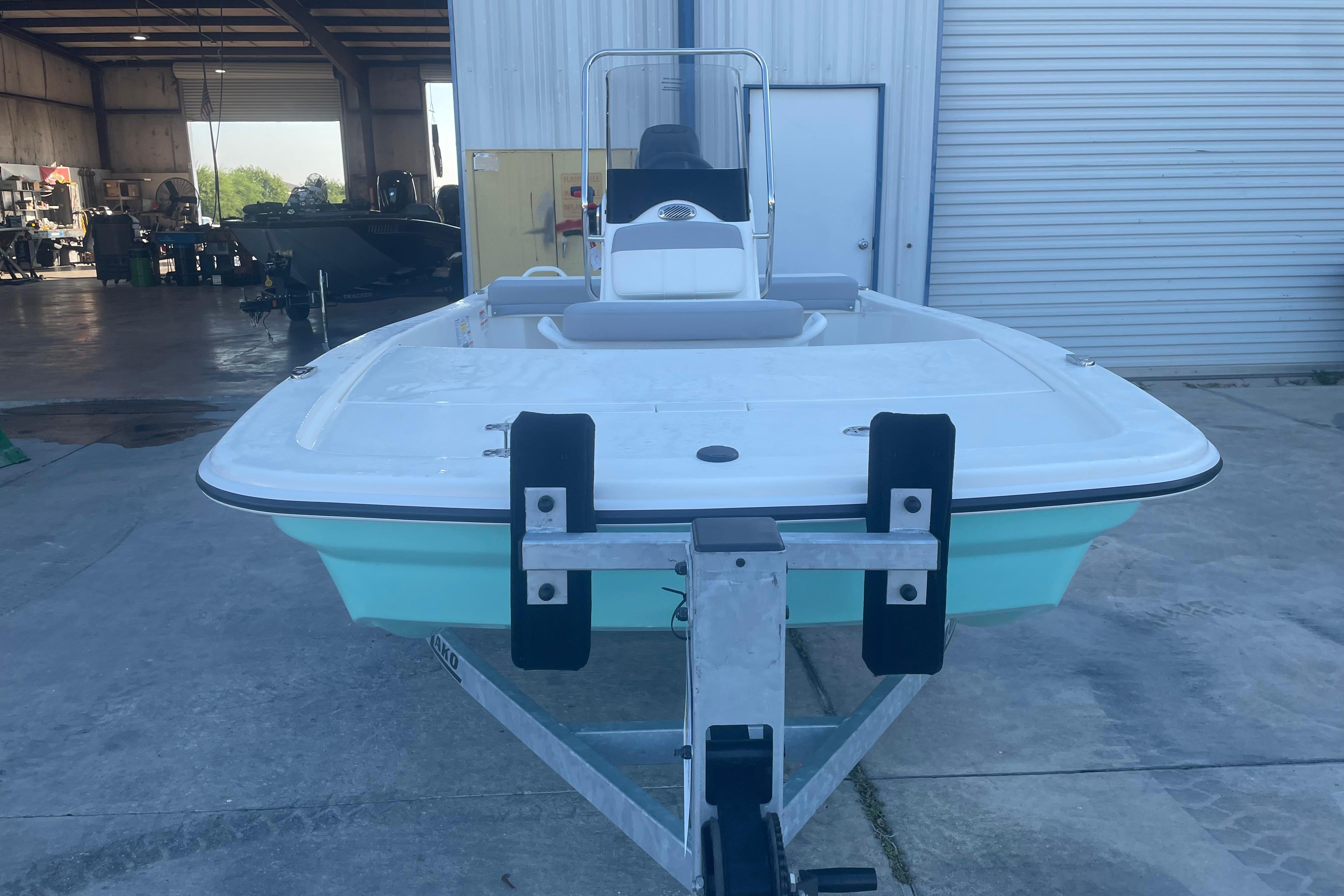 2026 Mako Pro Skiff 13 CC boat on trailer in a warehouse setting.