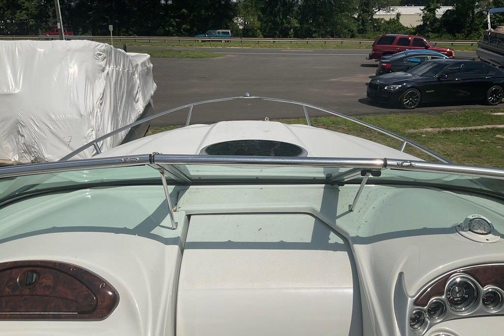 2015 Crownline 236 SC boat dashboard with steering wheel and gauges, parked outdoors.