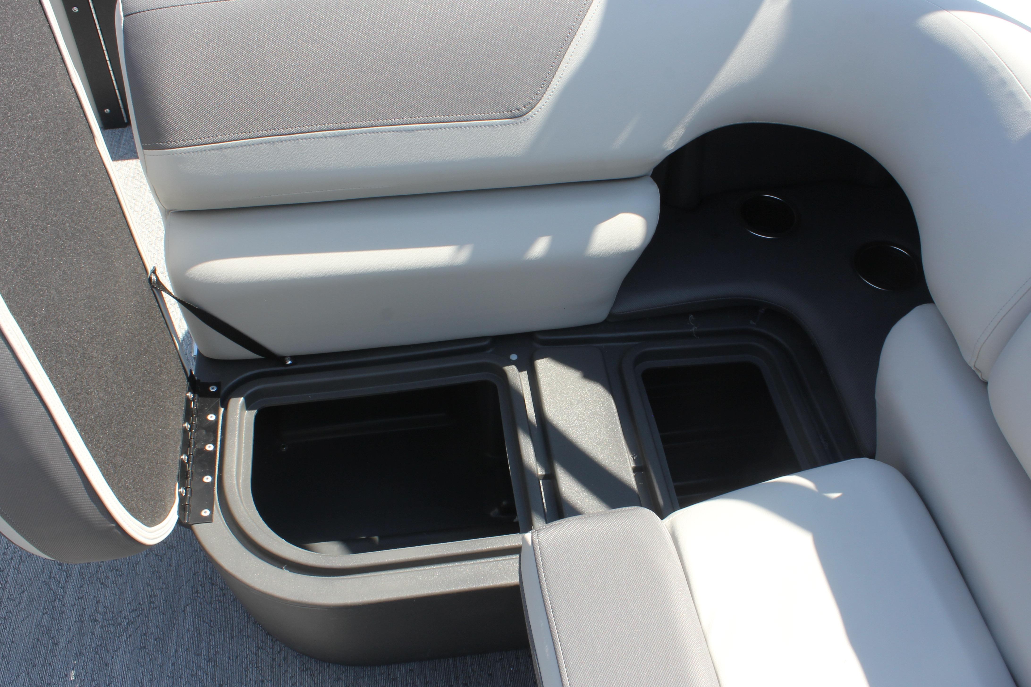2026 Sun Tracker Fishin' Barge 20 DLX storage compartment with cushioned seating.