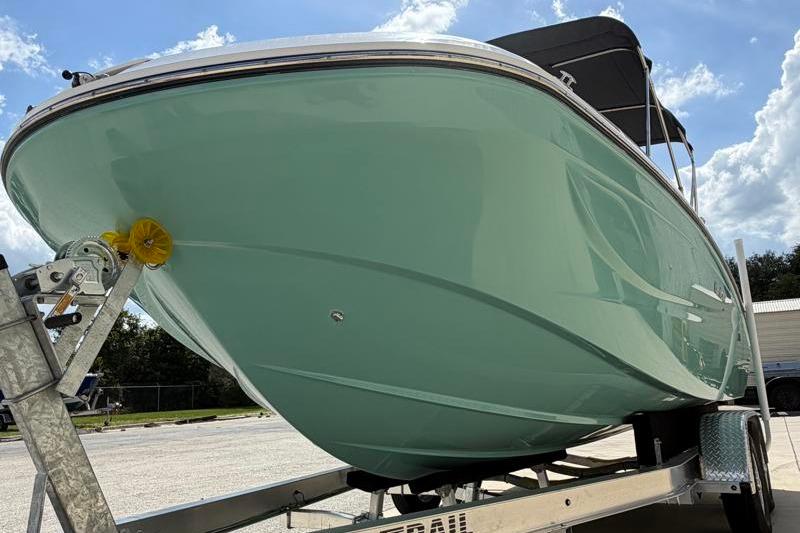 2026 Hurricane SunDeck Sport 2050 OB boat on trailer under blue sky.
