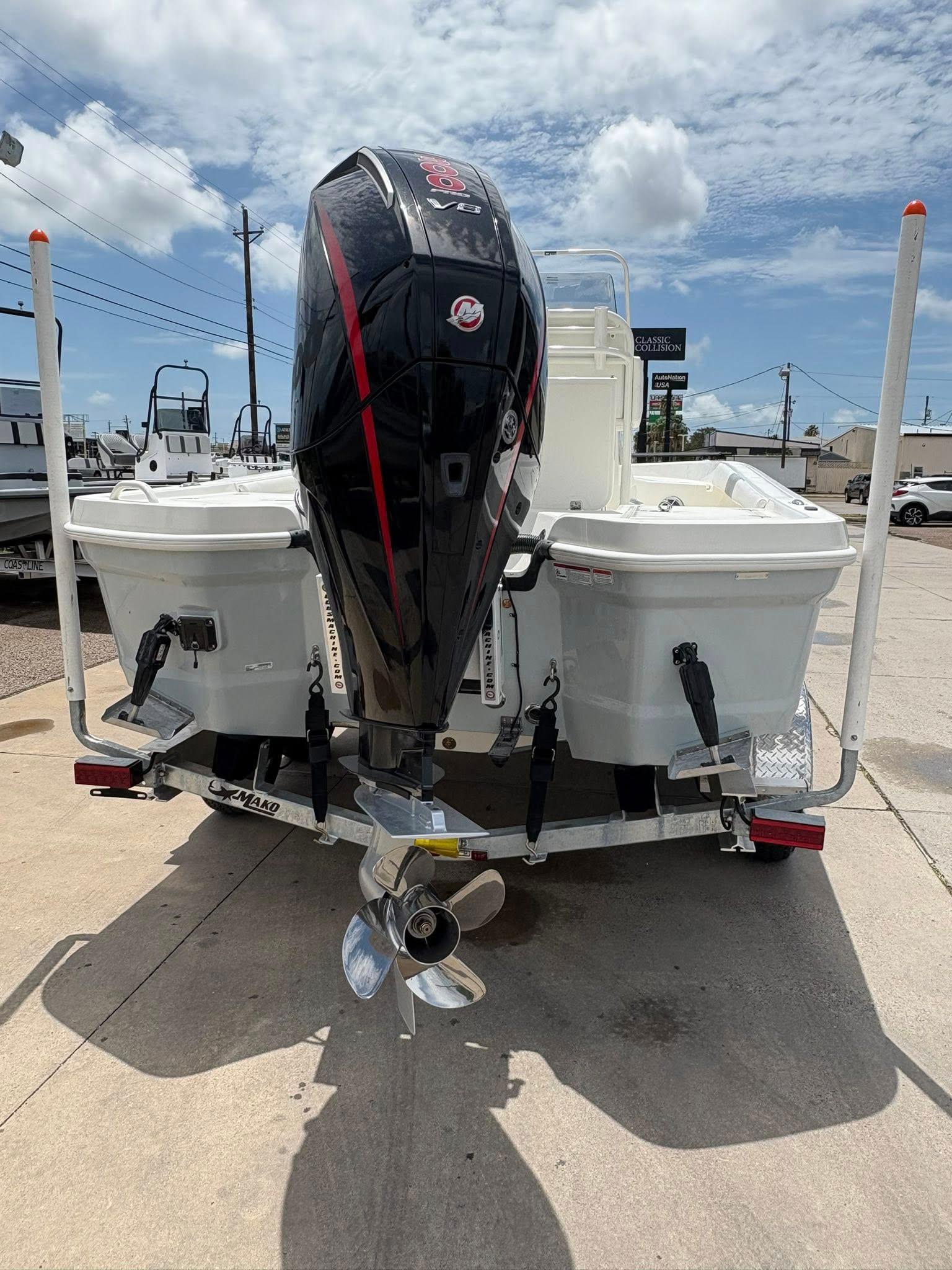 2025 Mako 24 APEX boat with powerful outboard motor on trailer, under a partly cloudy sky.