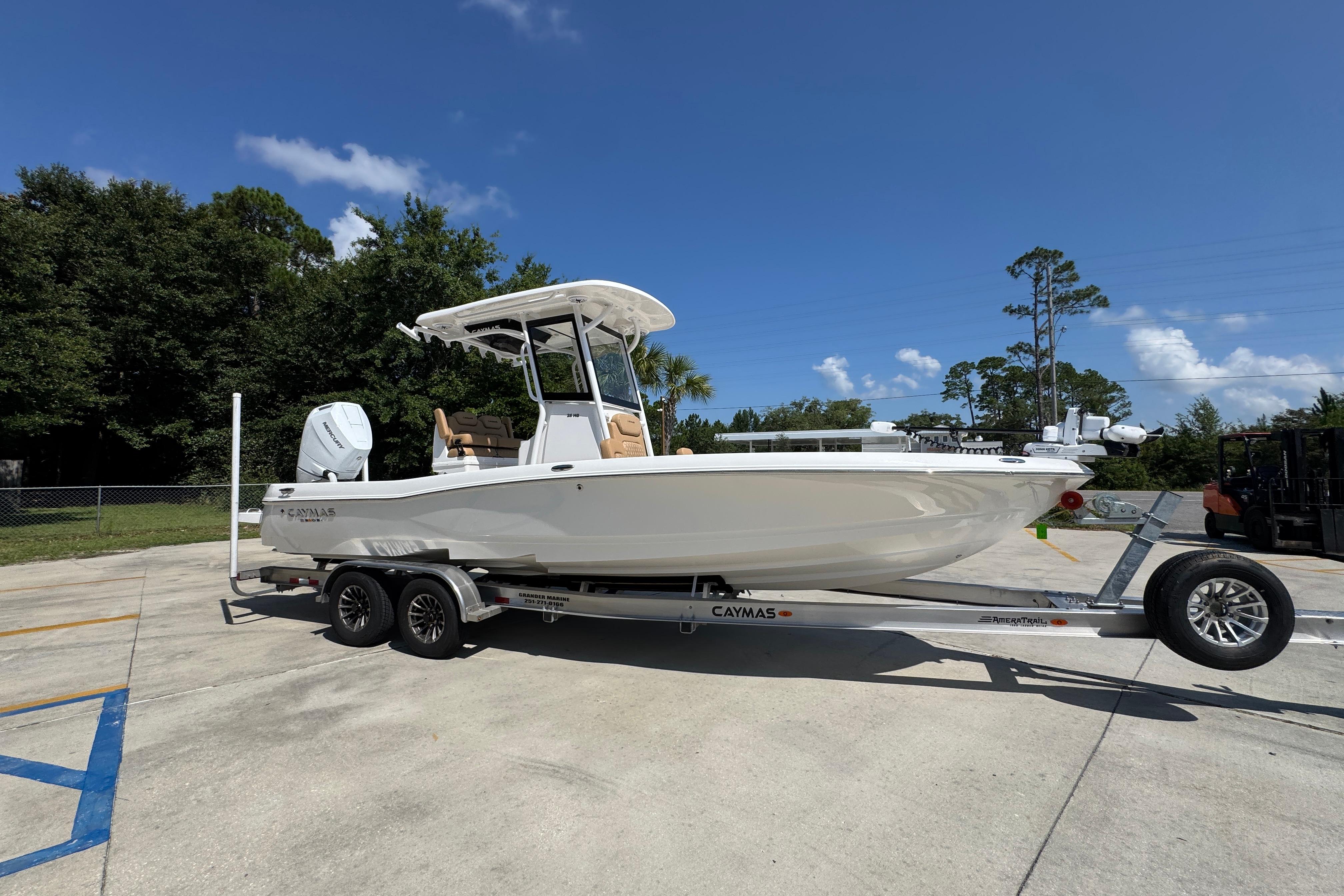 2027 Caymas 26 HB boat on trailer, parked outdoors under clear blue sky.