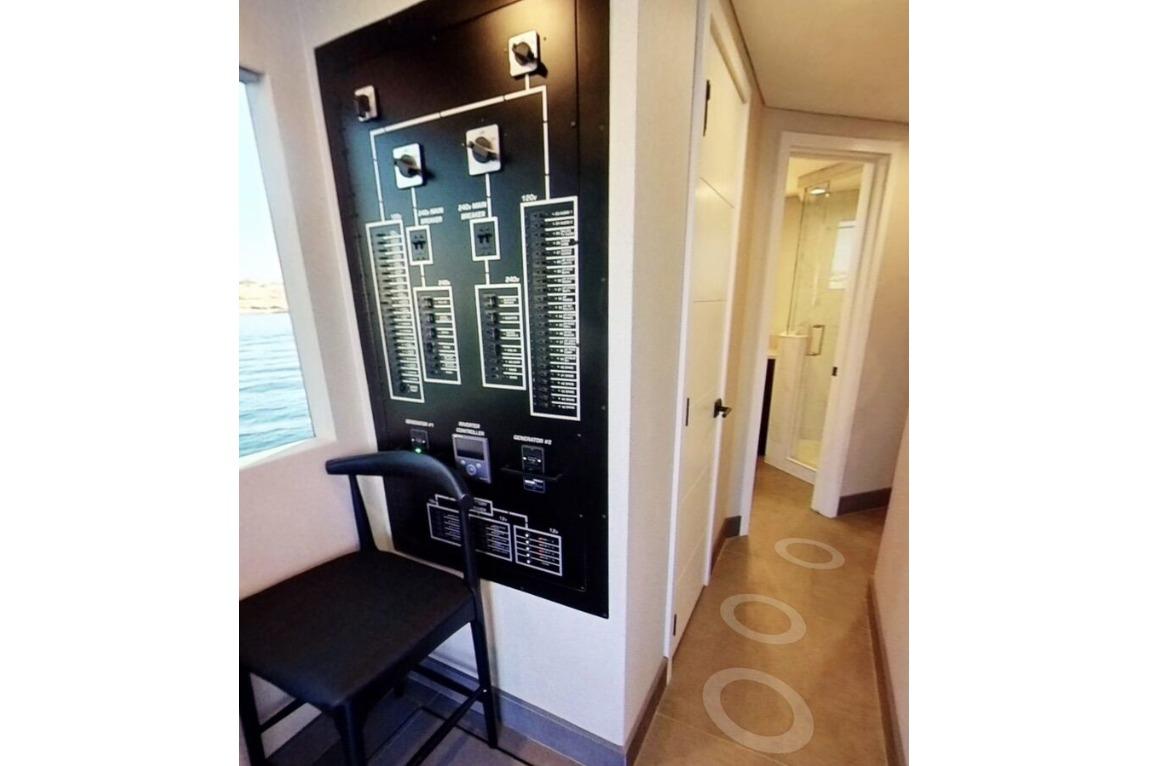 Control panel and chair in Adonia Galileo Trip #1, 2023, with hallway and bathroom view.