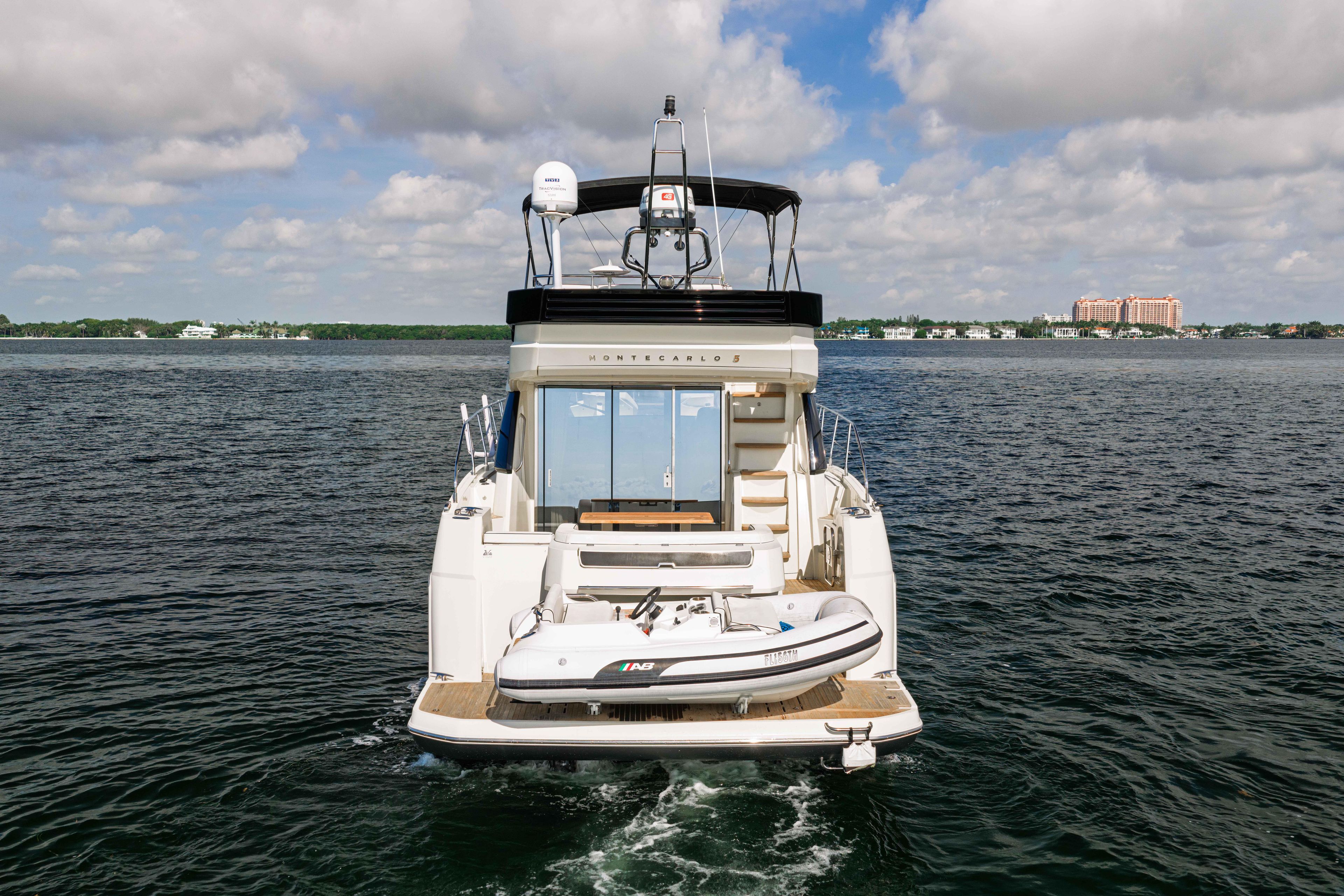 2017 Monte Carlo Yachts MC5 on open water, rear view with inflatable boat.