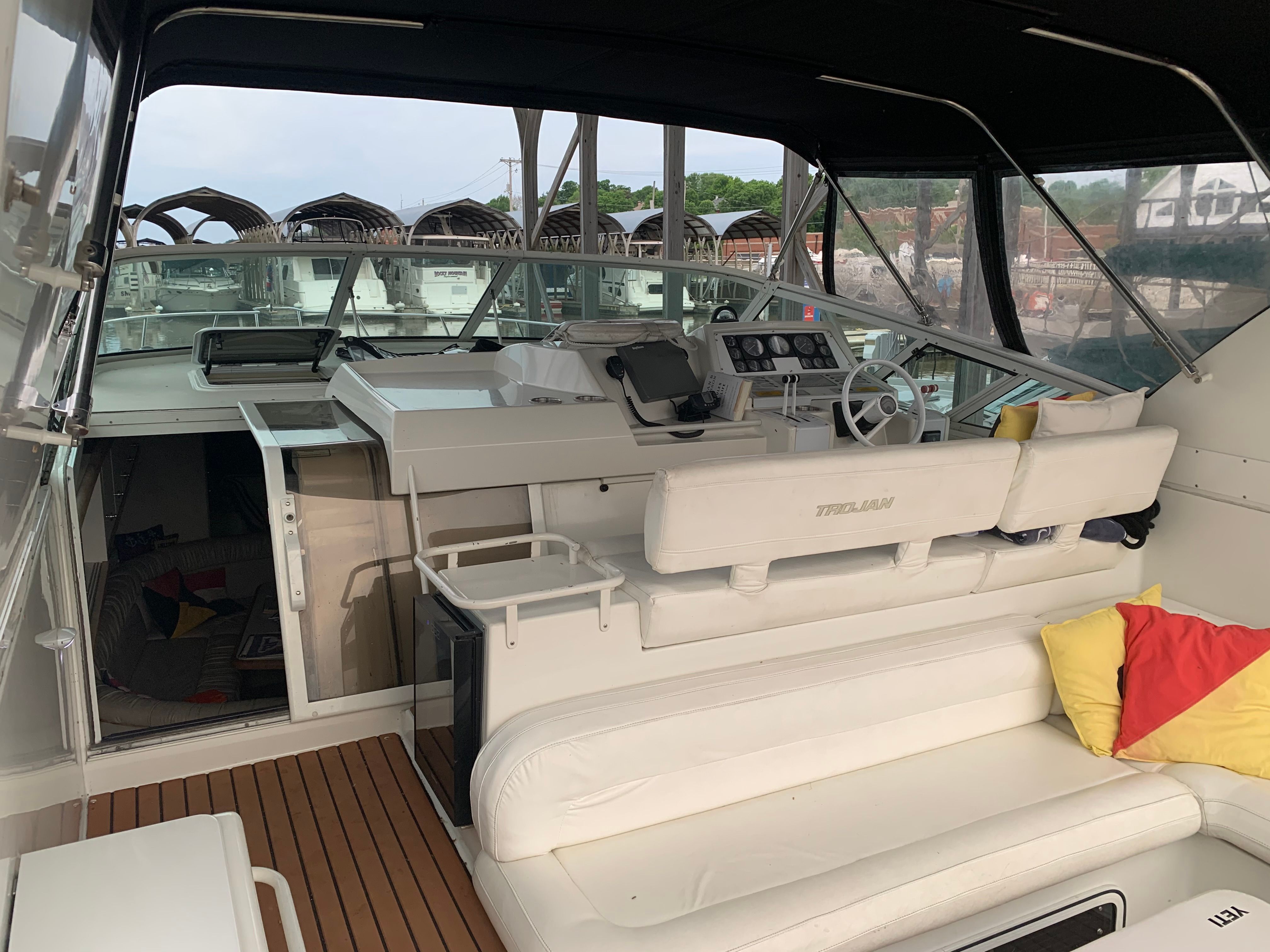 The image shows the cockpit of a 1995 Trojan 390x with white seating and a helm station.