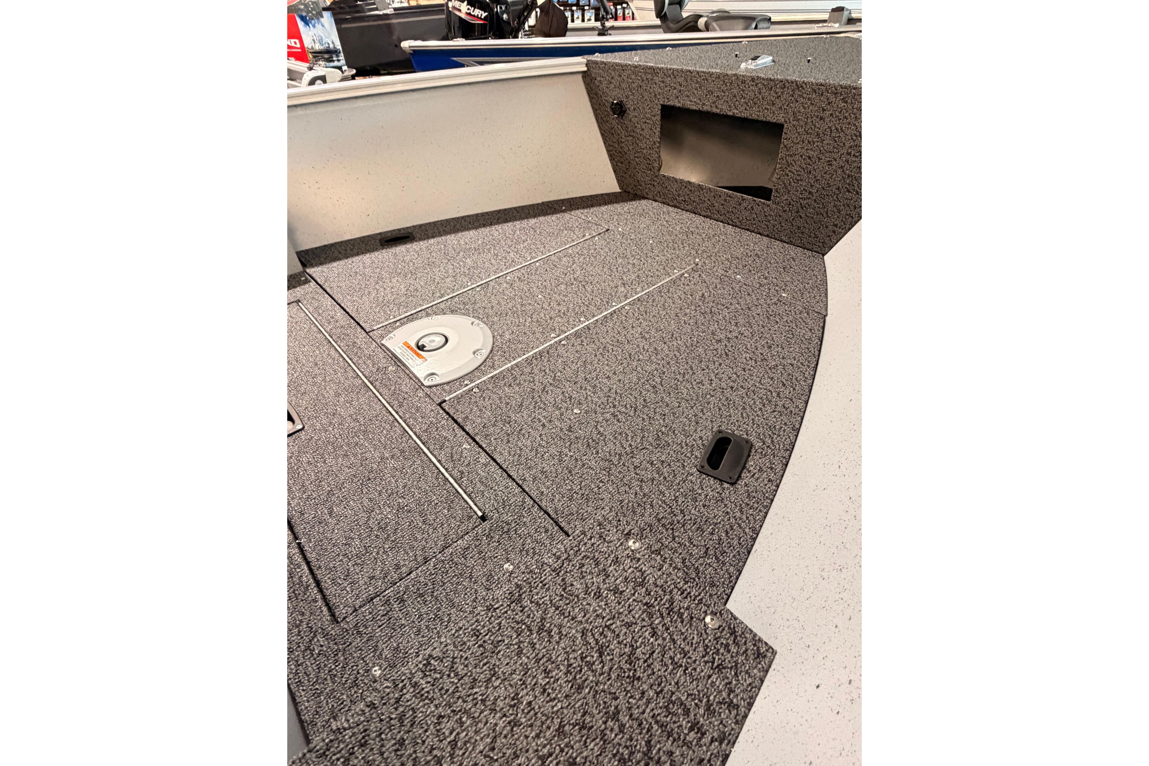 2027 Lund 1600 Fury SS boat interior with carpeted deck and storage compartments.