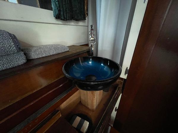 1951 Chris-Craft Catalina interior with modern blue vessel sink and wooden cabinetry.