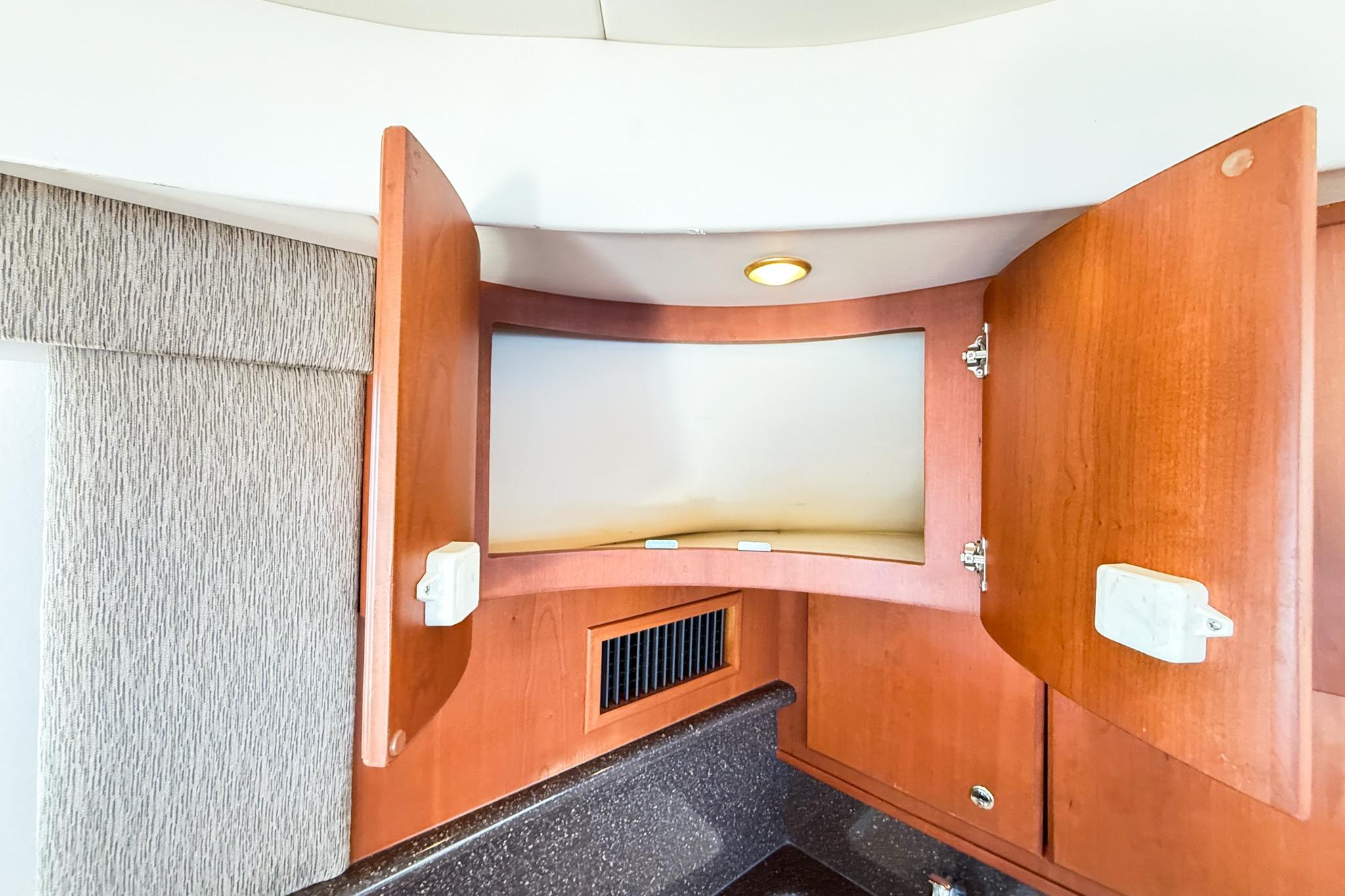 Open wooden cabinet in 2004 Silverton 48 Convertible yacht interior.