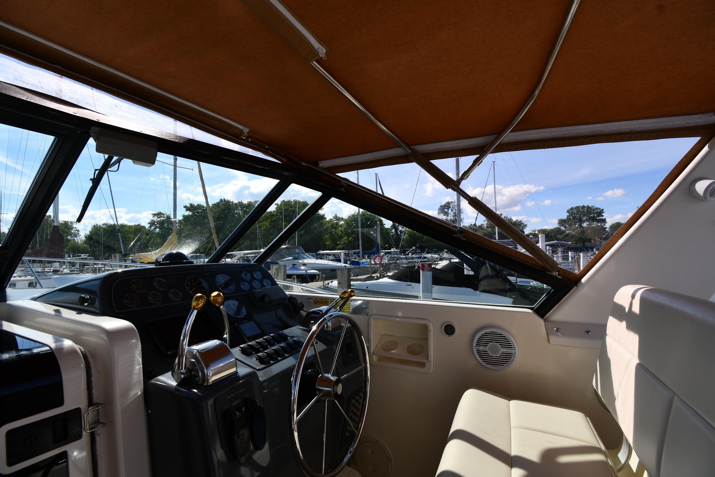 1998 Tiara Yachts 3100 Open helm with steering wheel and controls, docked at marina.