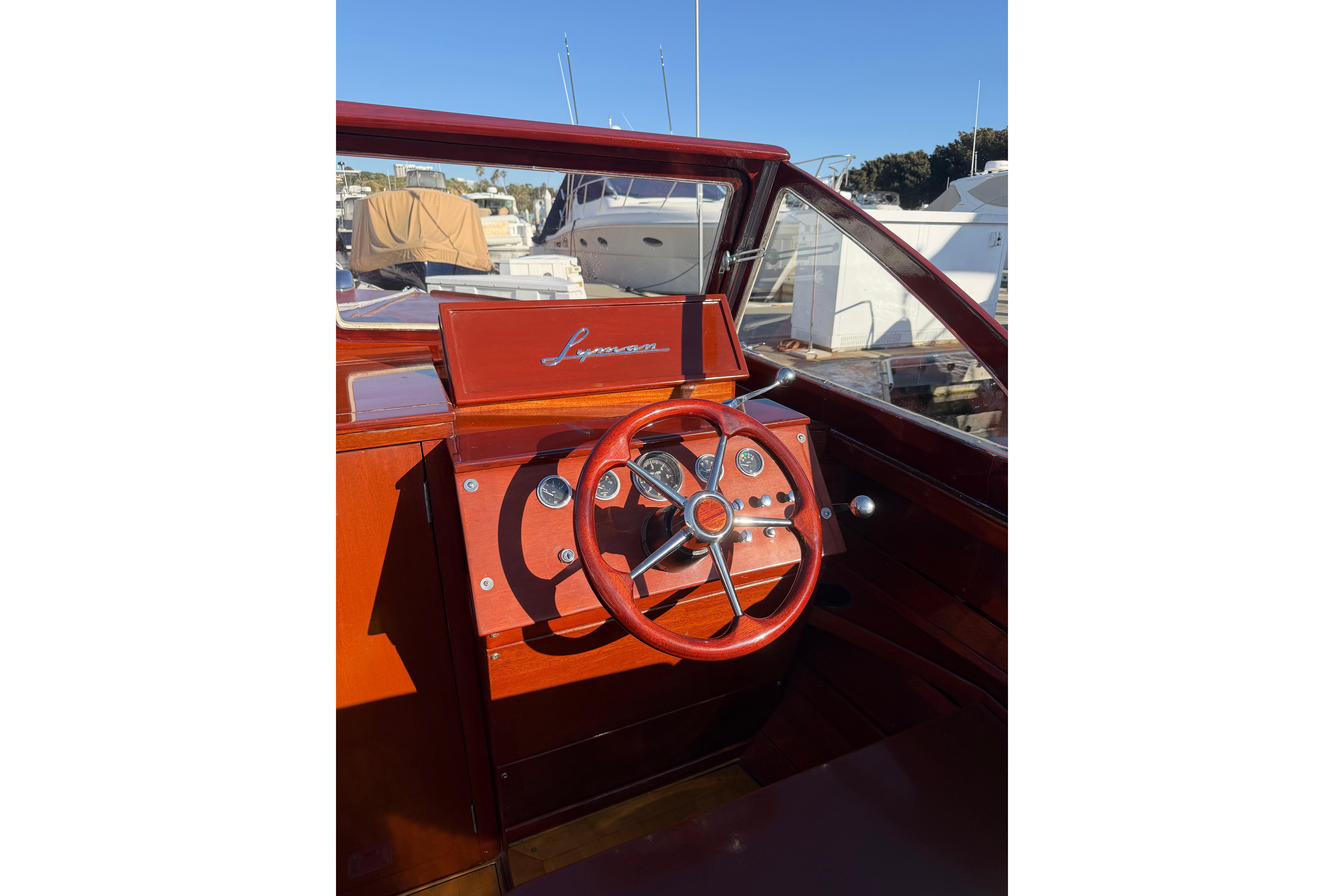 1964 Lyman 25 Sleeper boat dashboard with wooden steering wheel and classic design.