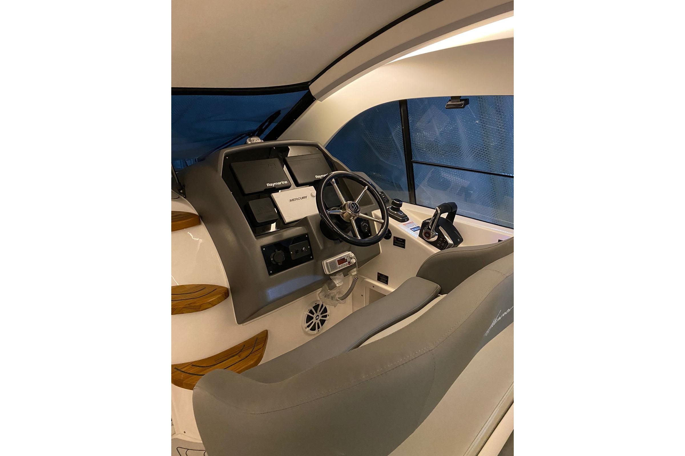 Interior view of 2026 Hanover 375 boat cockpit with steering wheel and controls.