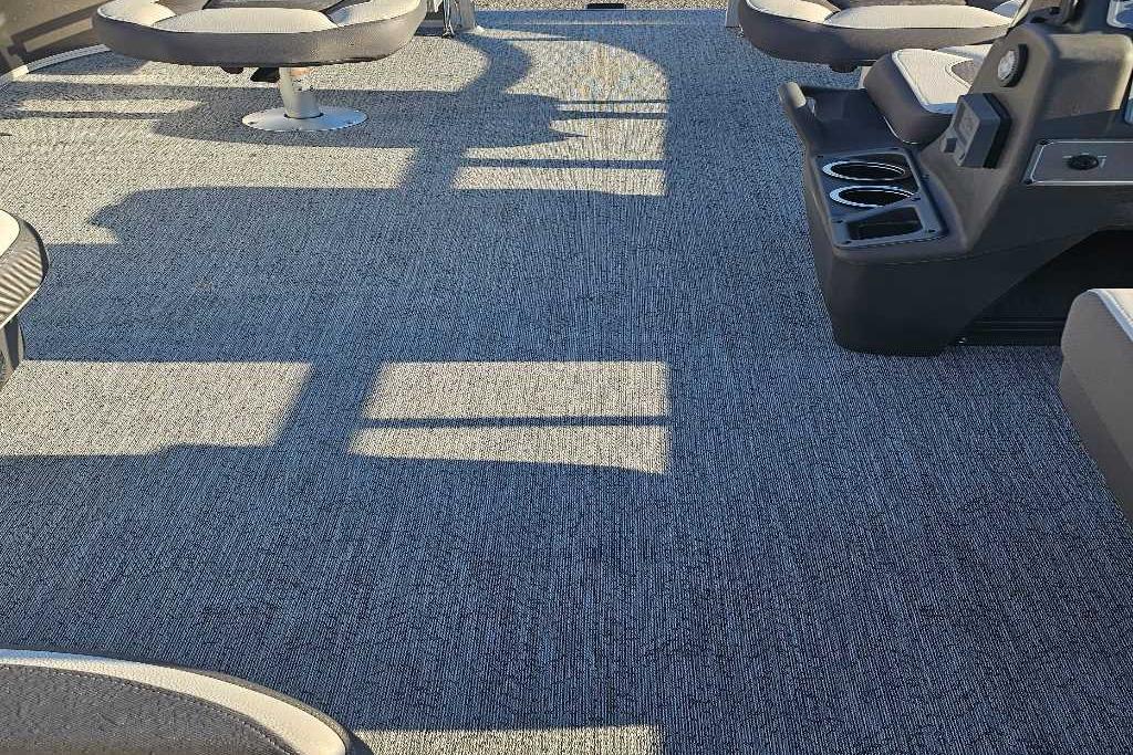 Interior of 2026 Sun Tracker Bass Buggy 16 XL Select pontoon boat with seating and carpeted floor.