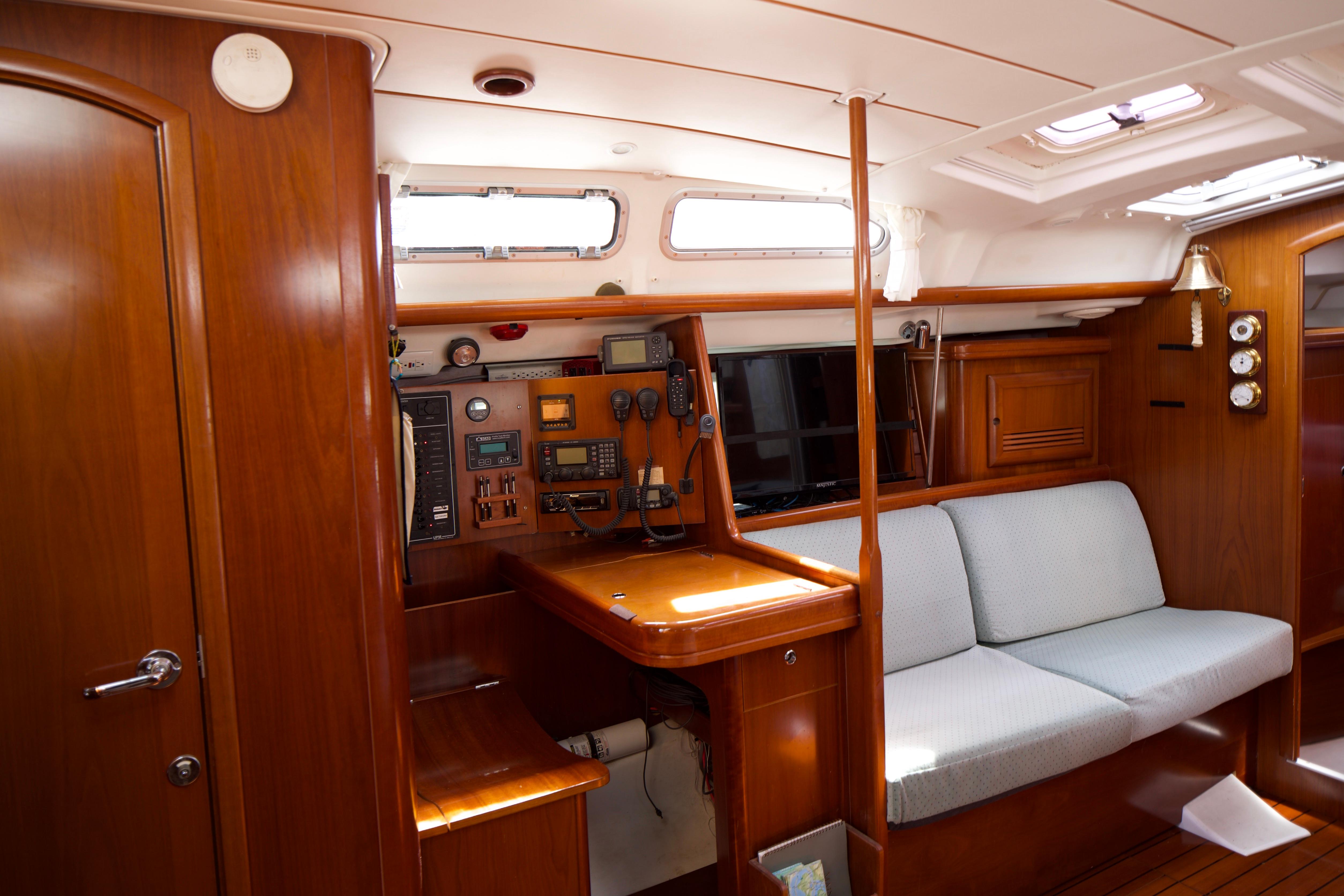 Interior of 2005 Beneteau 423 sailboat with navigation station and cozy seating area.