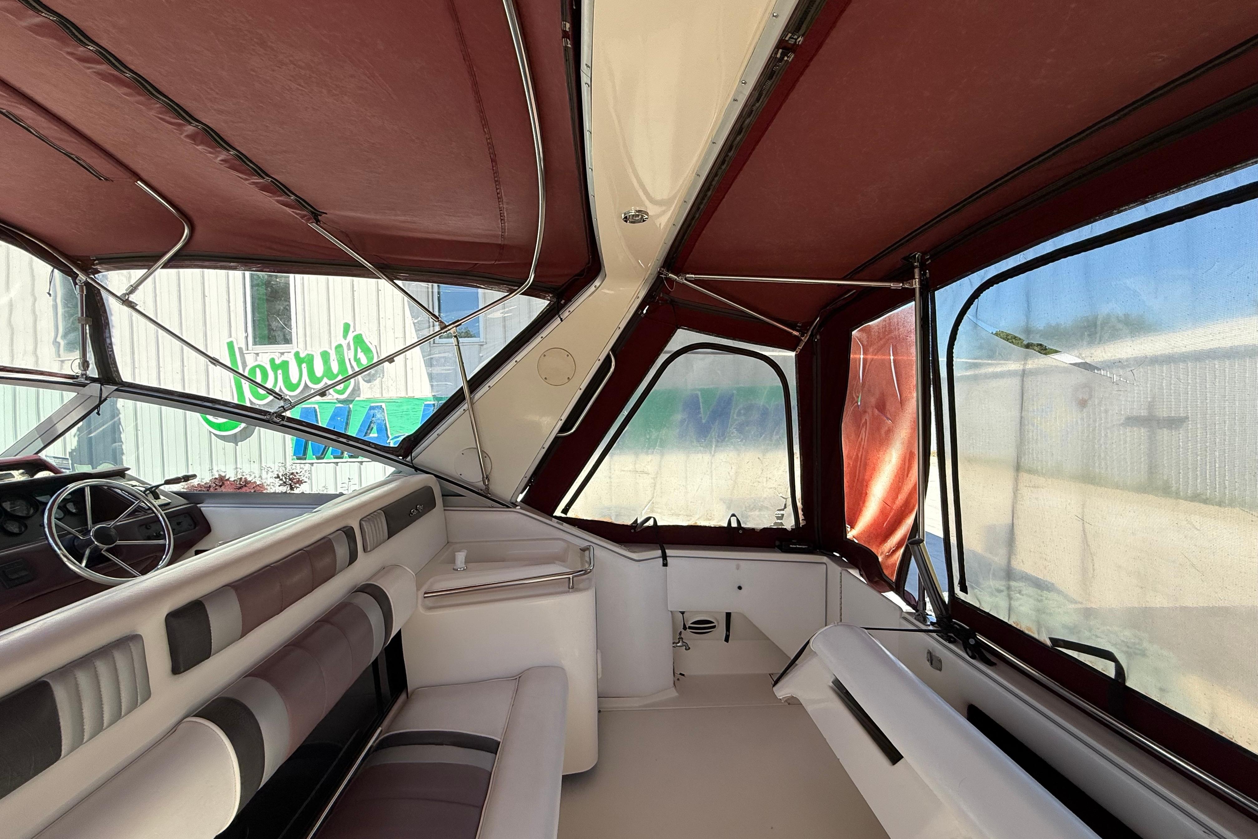 Interior of a 1990 Sea Ray 310 Express Cruiser with maroon canopy and seating.