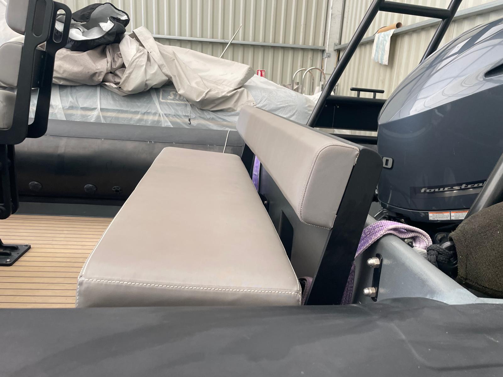 2014 Tornado 8.5 Multi Purpose boat interior with seating and engine in a storage area.