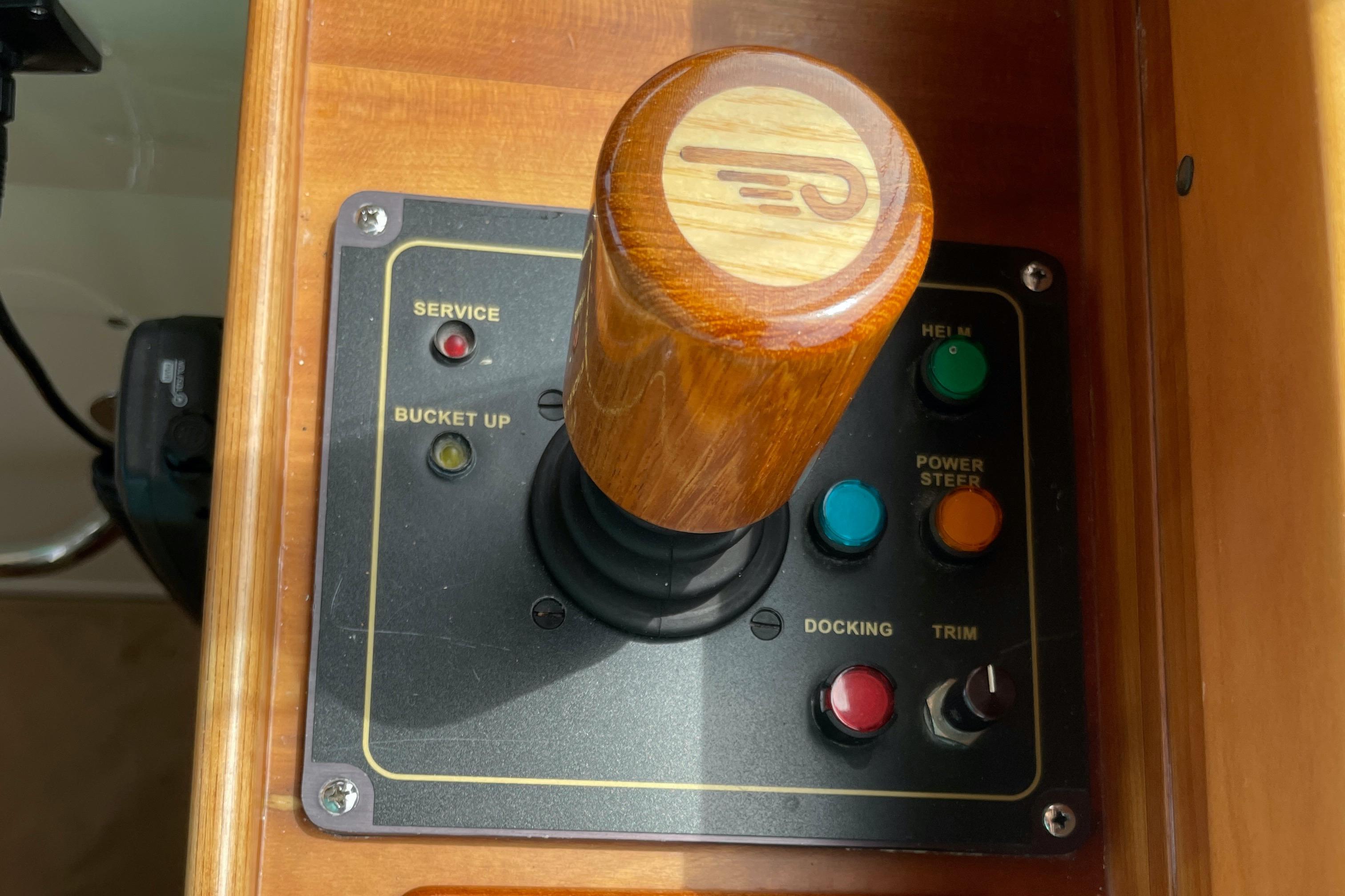 Control panel of a 2007 Hinckley Talaria 44 Flybridge with wooden joystick and buttons.