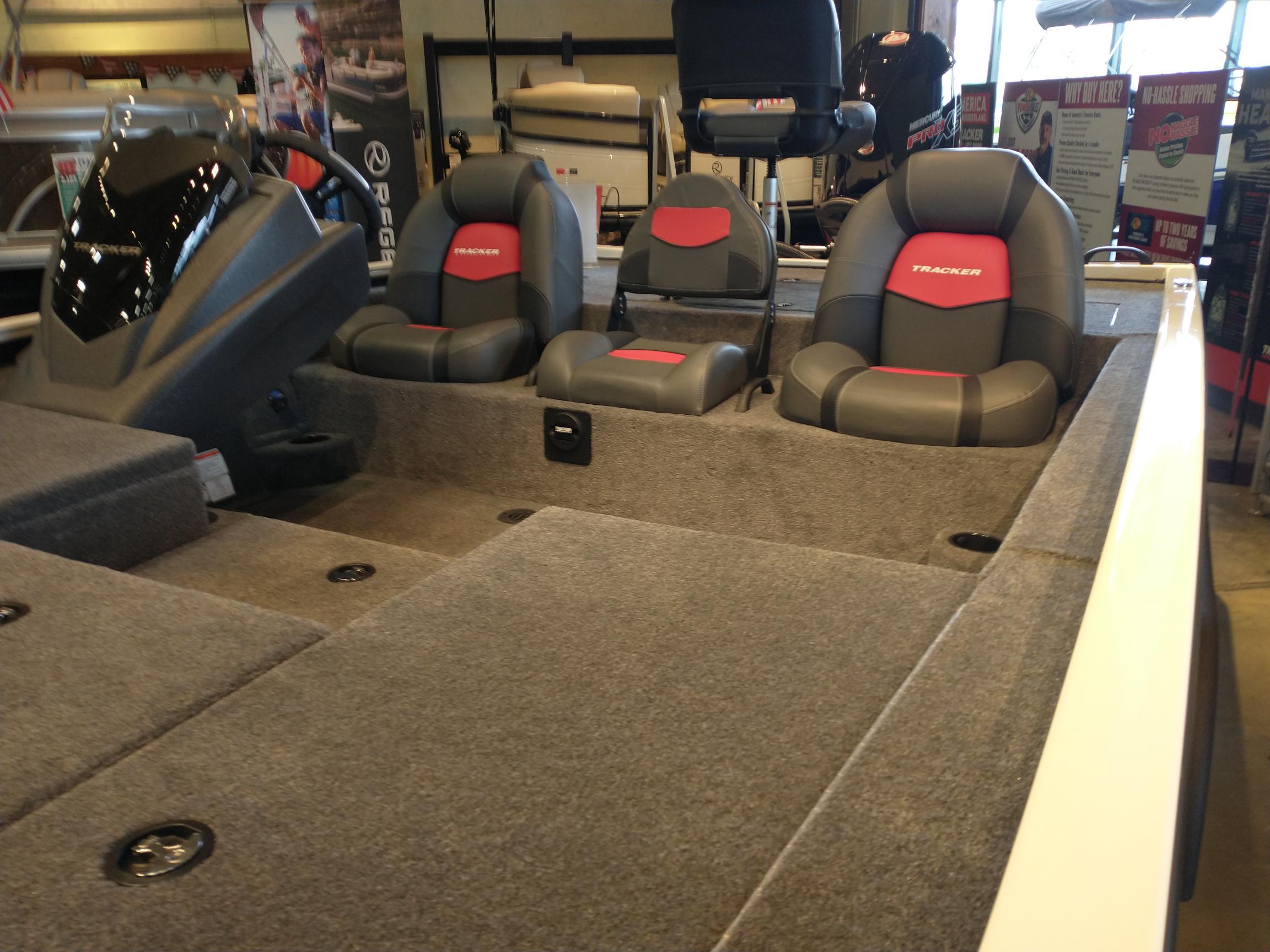 2025 Tracker Savage 215 boat interior with gray and red seating, displayed indoors.