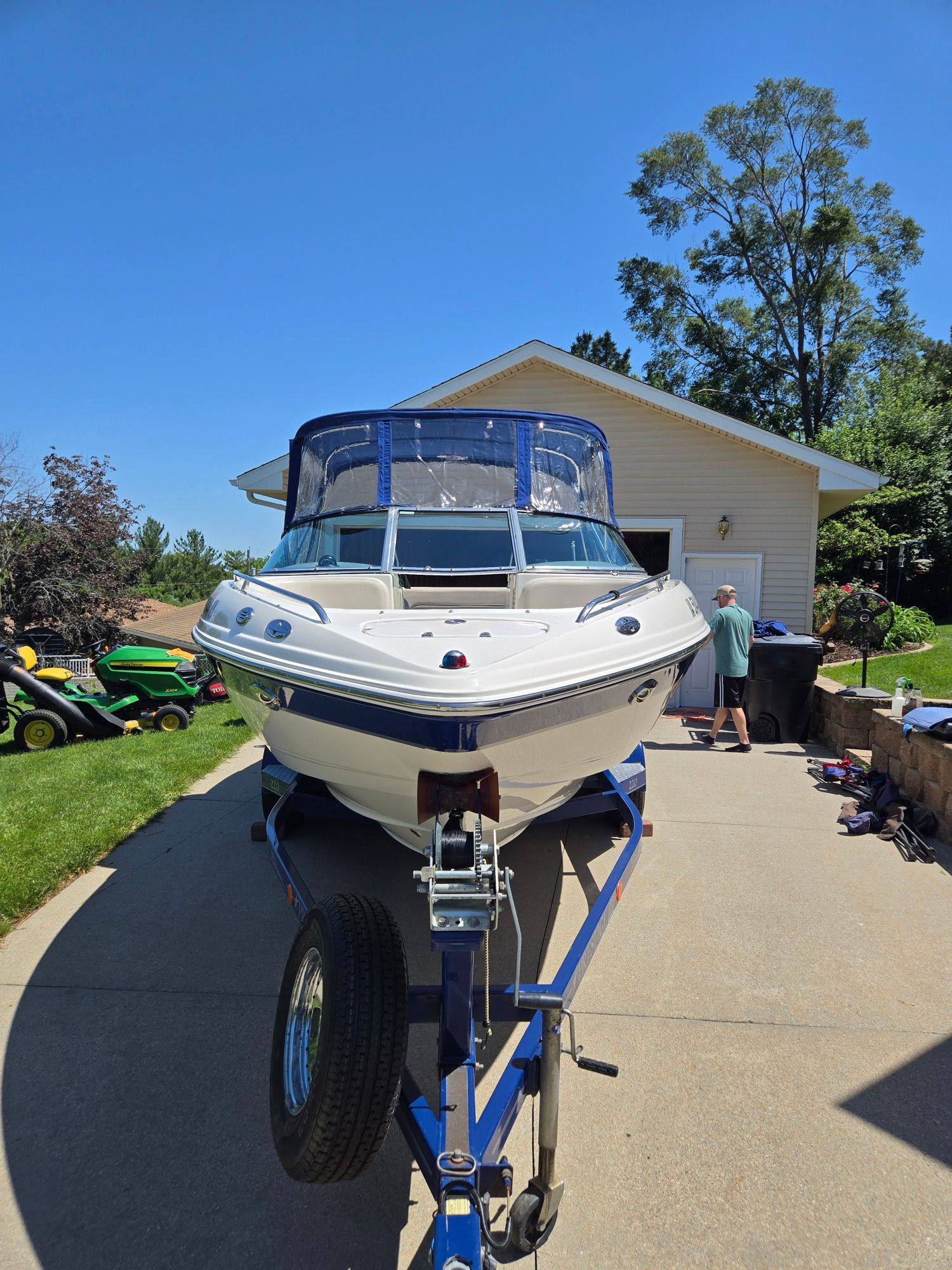 A 2005 Chaparral 220 SSi boat on a trailer in a driveway.
