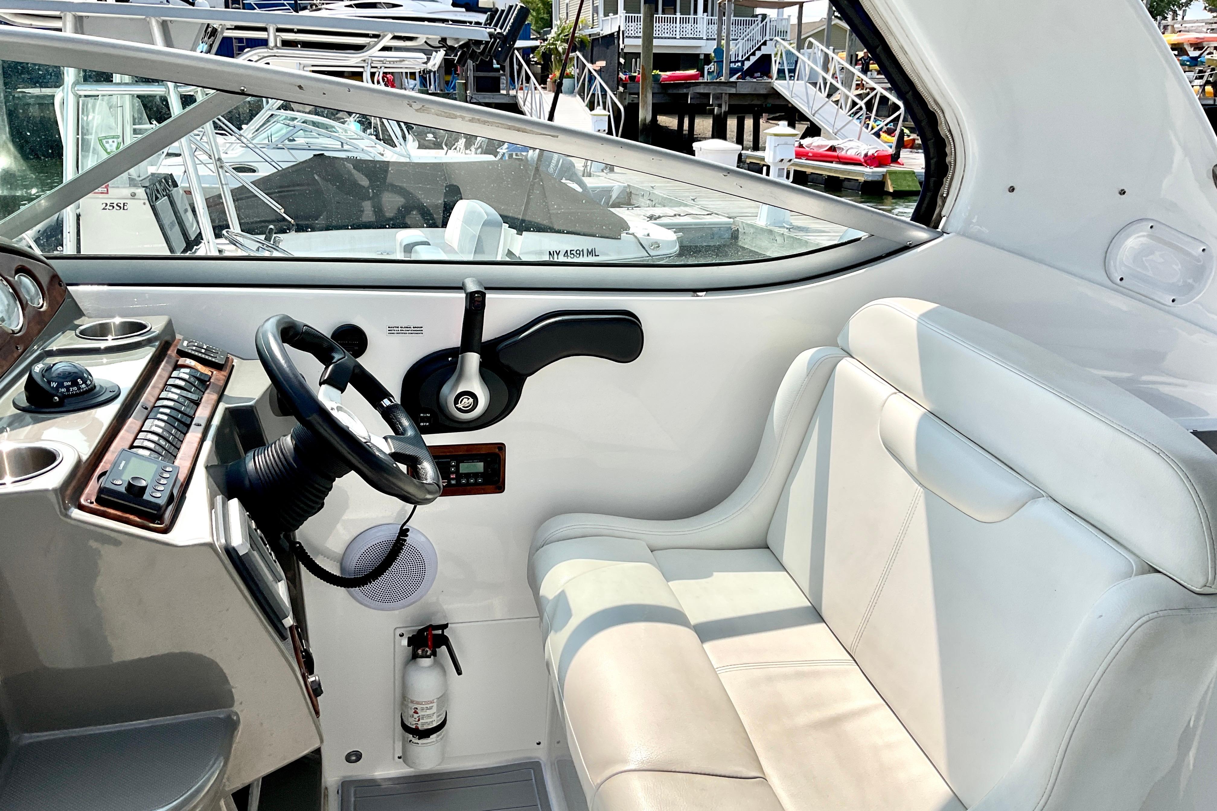 2013 Rinker 290 Express Cruiser cockpit with steering wheel and seating area.