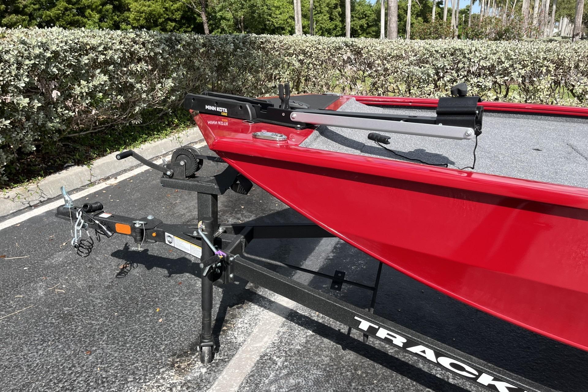 Red 2026 Tracker Pro 170 boat on trailer, parked outdoors.