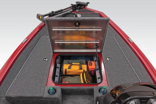 A red boat with an open storage compartment filled with fishing gear and accessories.