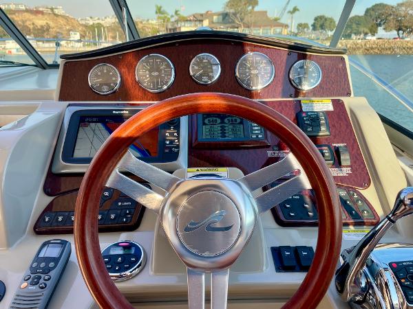 2014 Sea Ray 330 Sundancer helm with wooden steering wheel and modern navigation instruments.