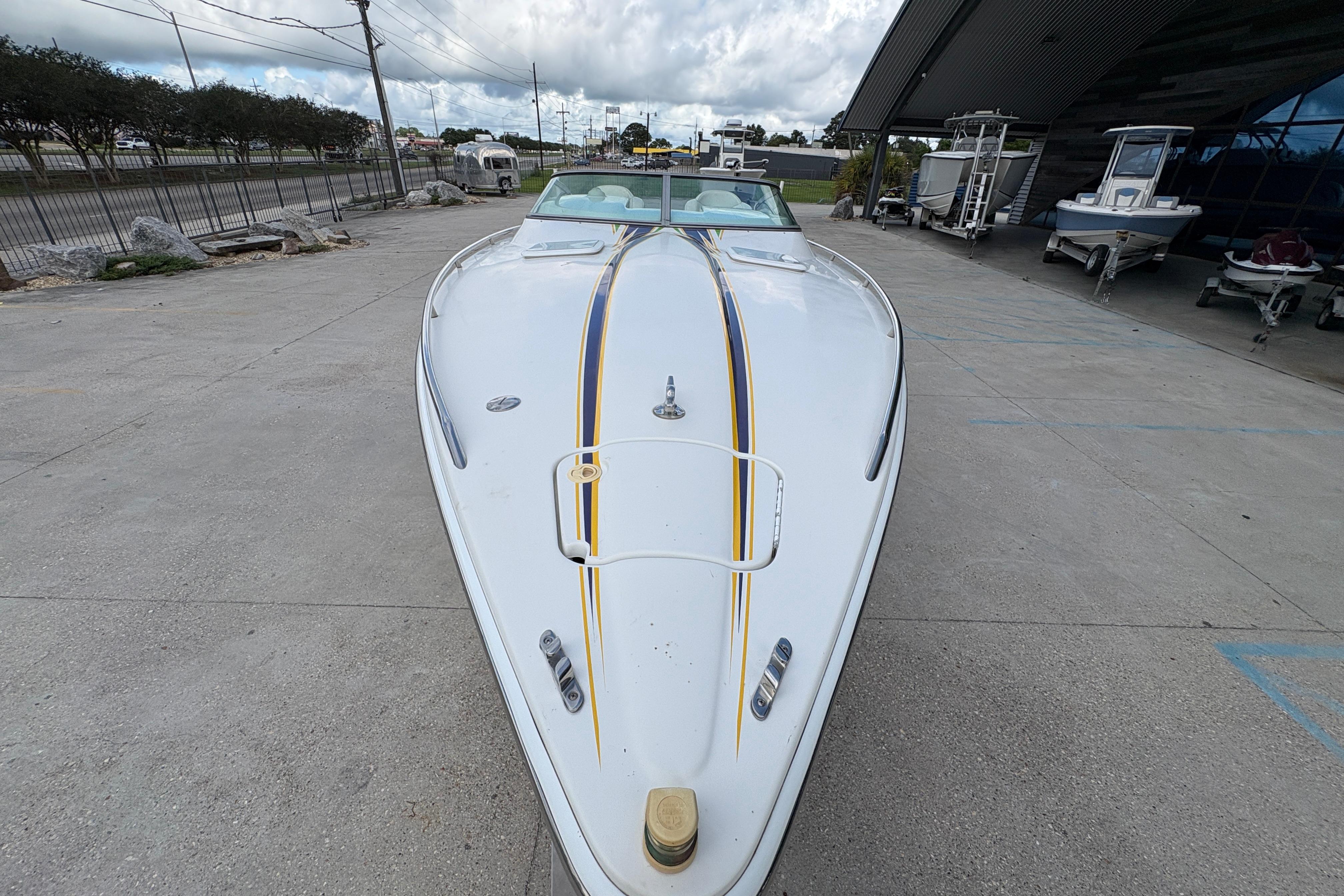 2002 Formula 292 FASTech boat with sleek design, parked outdoors on concrete surface.