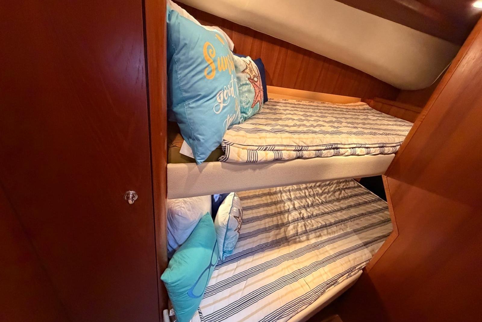 Bunk beds in 2007 Tiara Yachts 3900 Convertible cabin with striped bedding and decorative pillows.