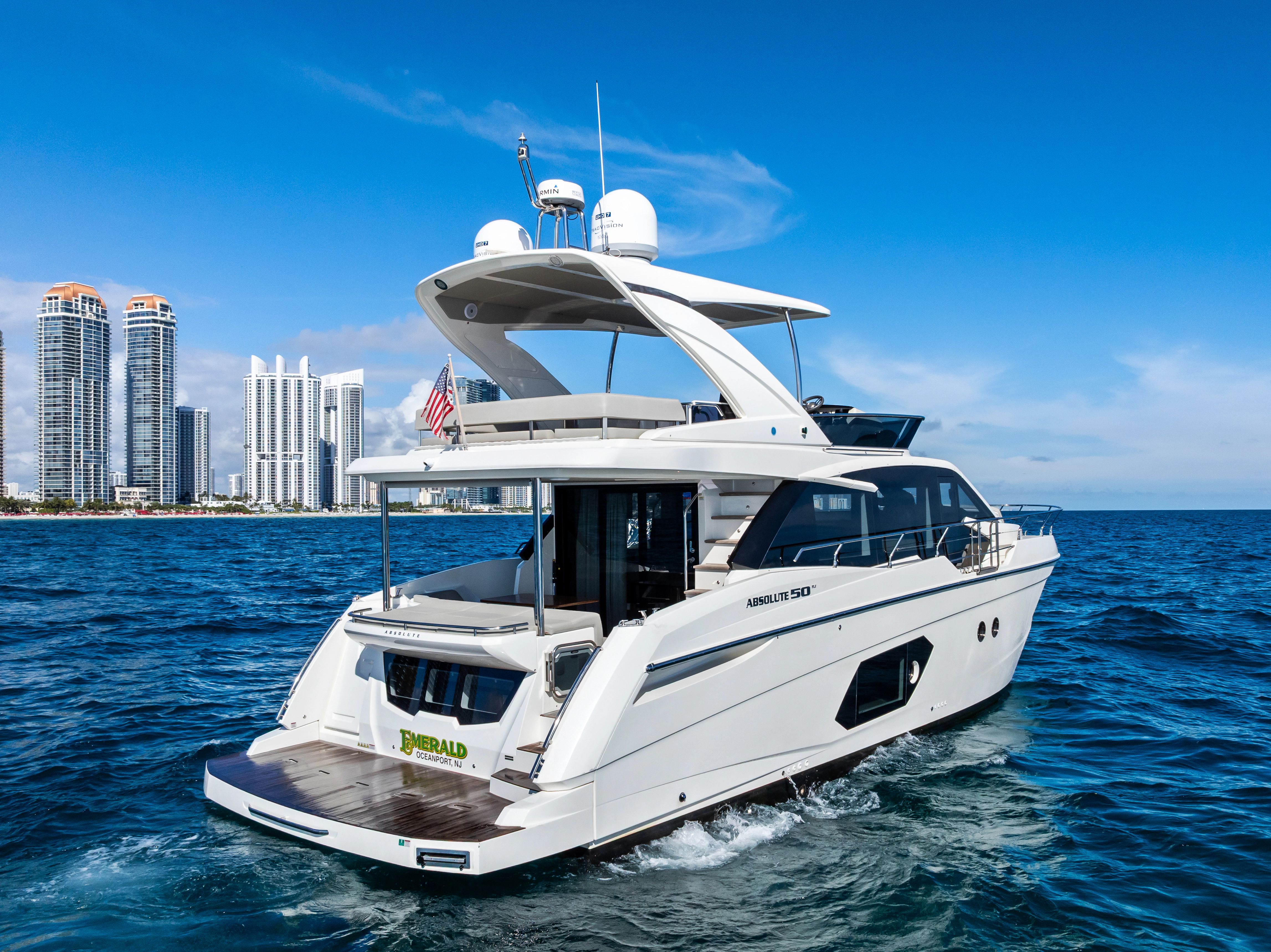 Luxury yacht Absolute 50 Fly 2023 near city skyline.