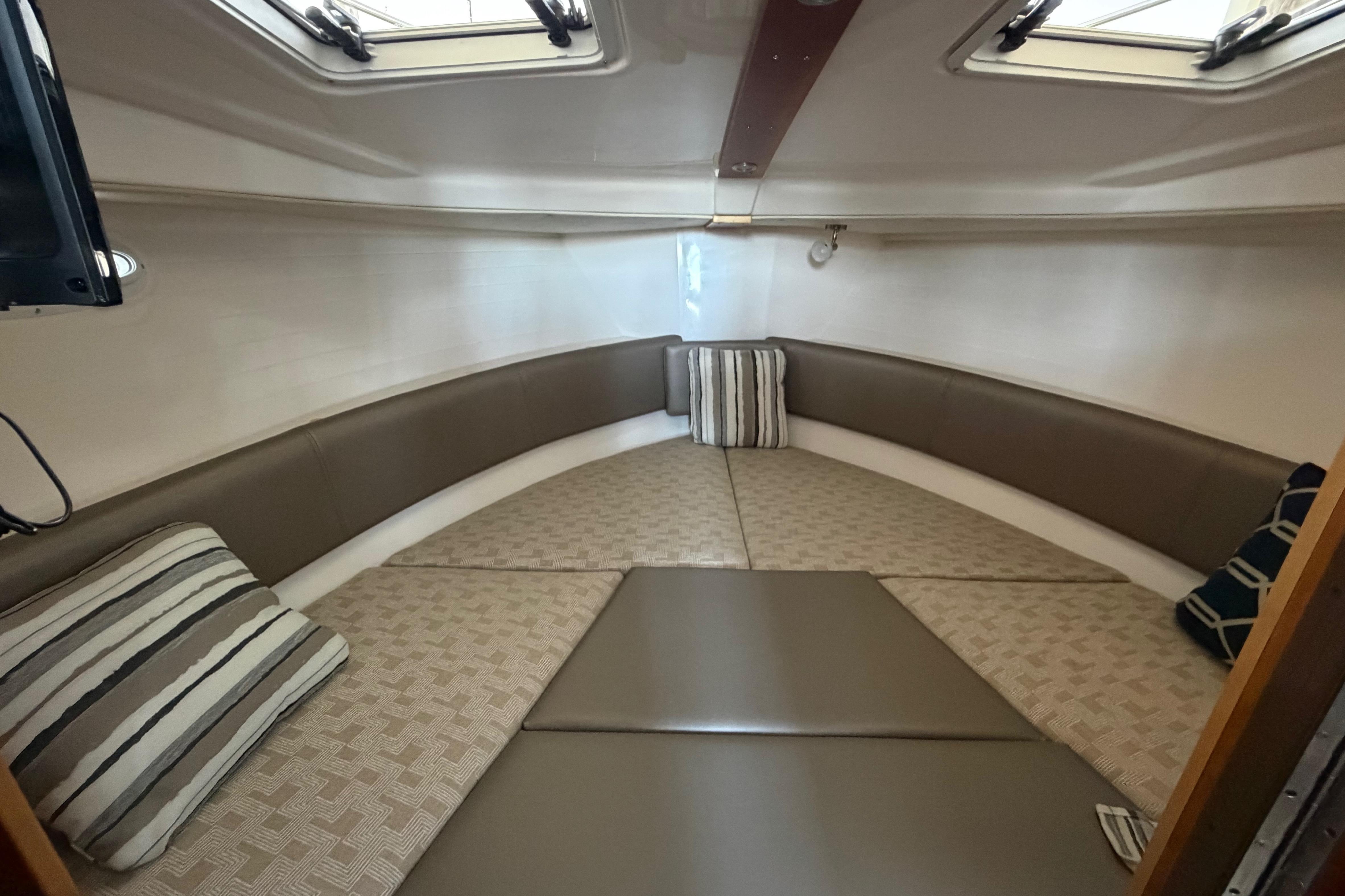 2023 Cutwater C-288 Coupe interior cabin with cozy seating and striped cushions.