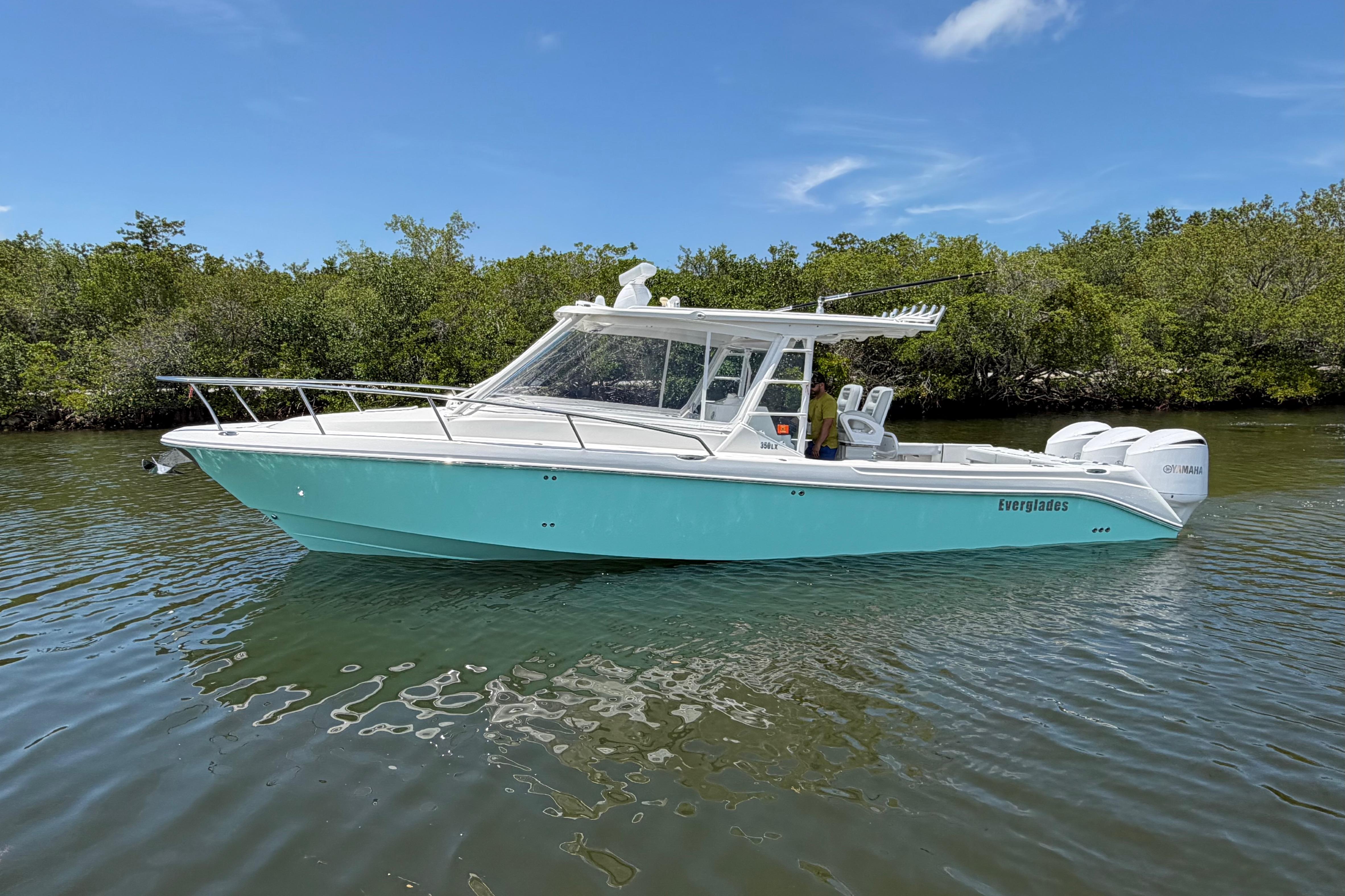 2009 Everglades 350LX boat on calm water, surrounded by lush greenery.