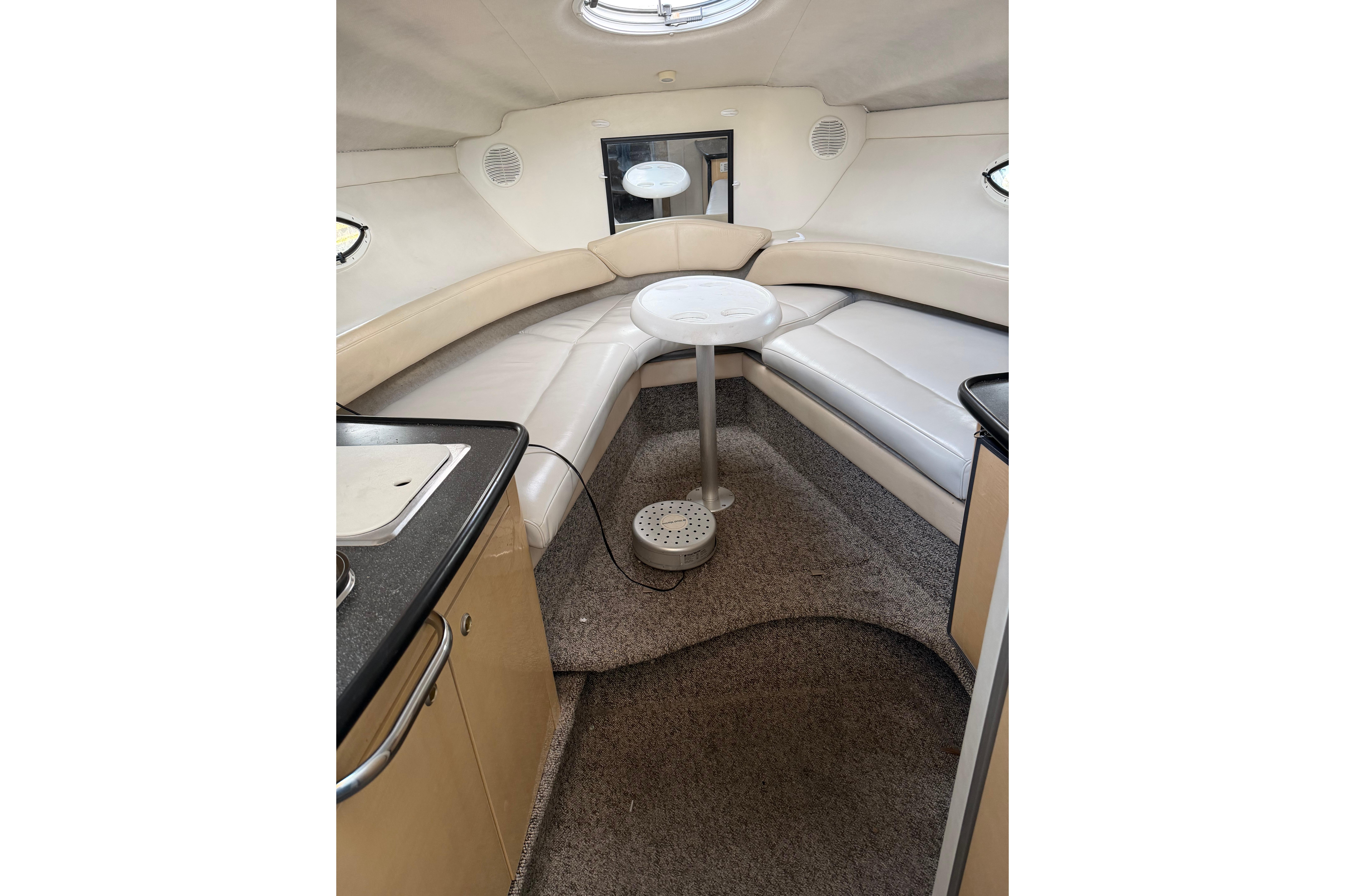 Interior of 2001 Maxum 2800 SCR boat with cozy seating and compact table.