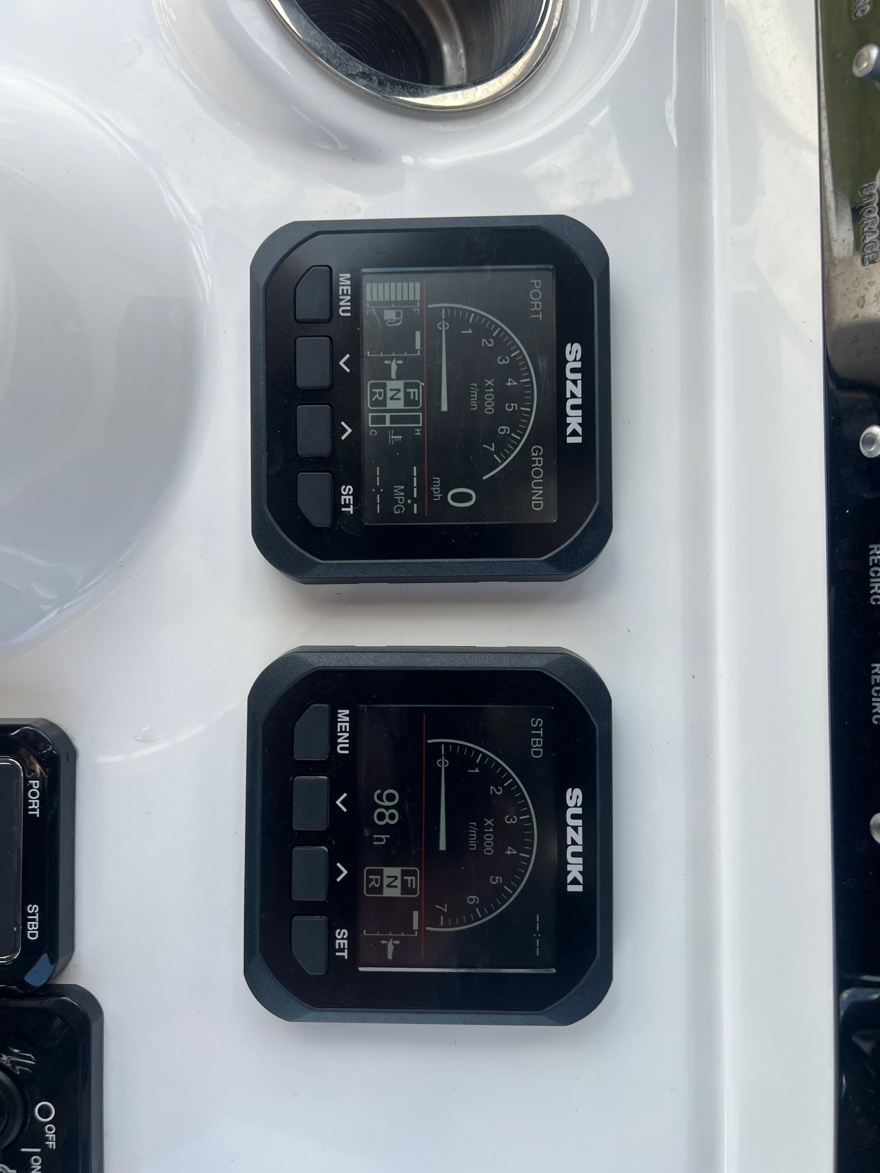 Two Suzuki gauges on a boat panel display speed and other data.