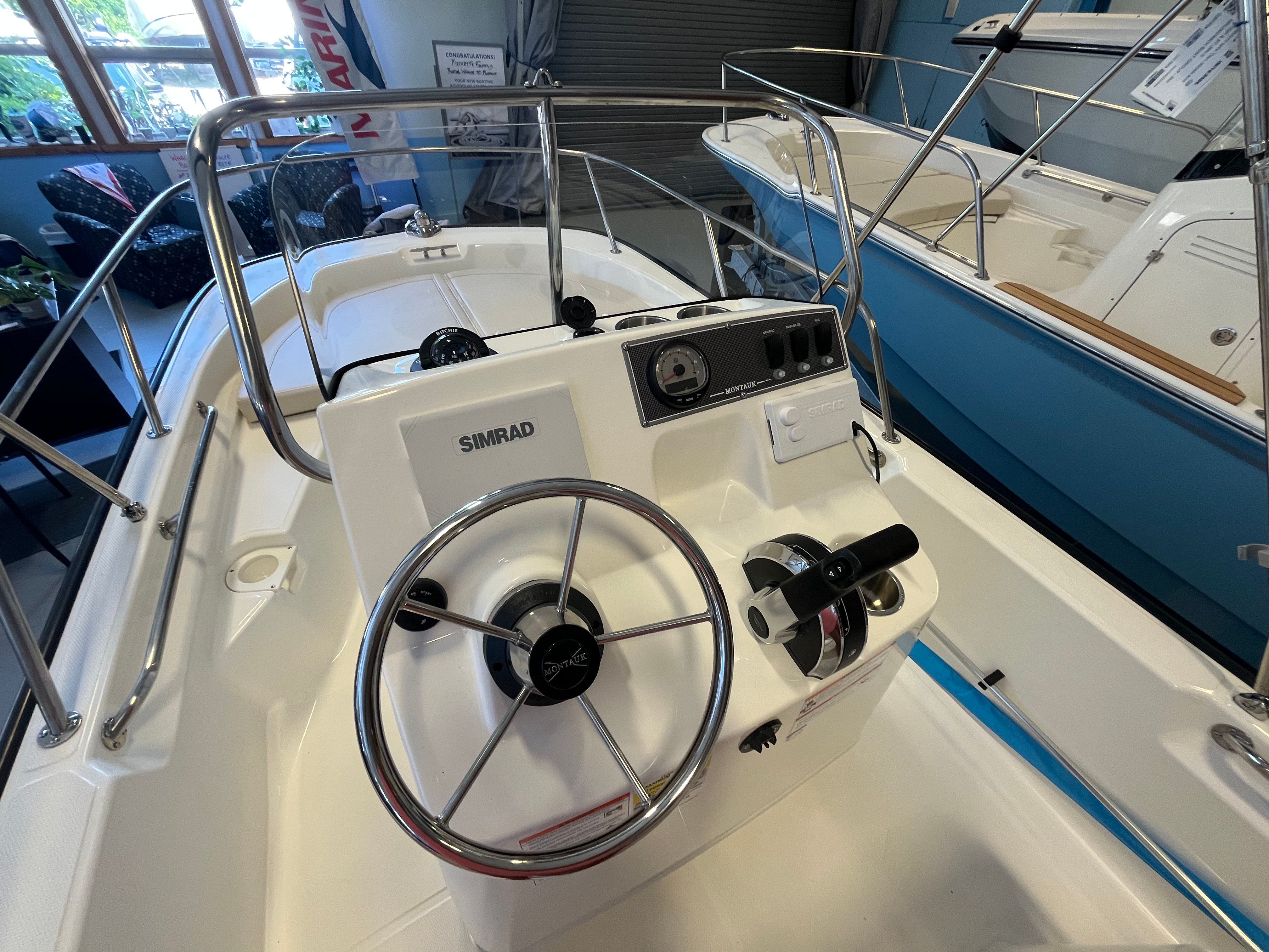 The image shows the cockpit of a Boston Whaler 150 Montauk with a Simrad control system.