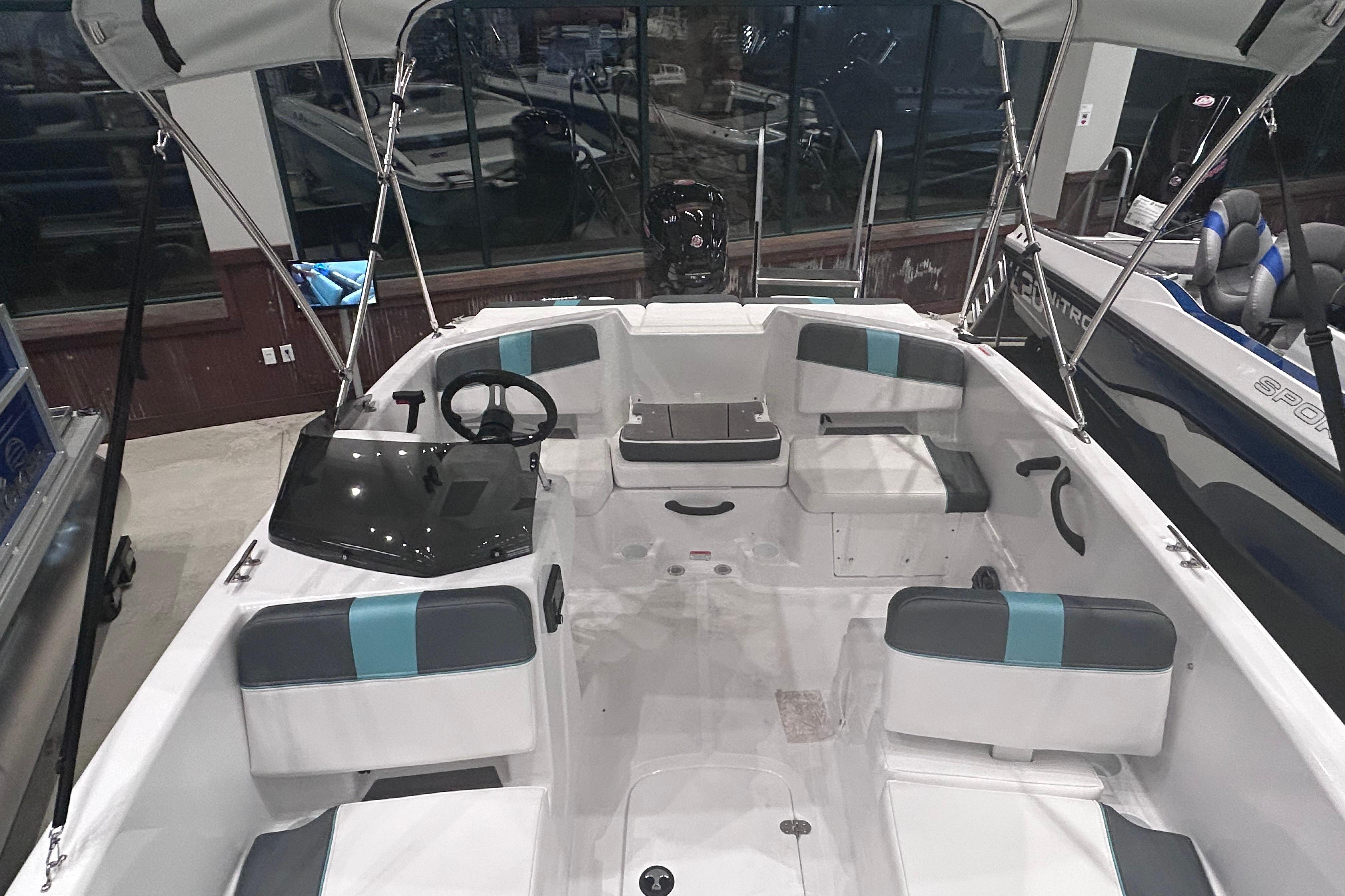 2026 Tahoe T18 boat interior with seating and steering wheel, displayed indoors.