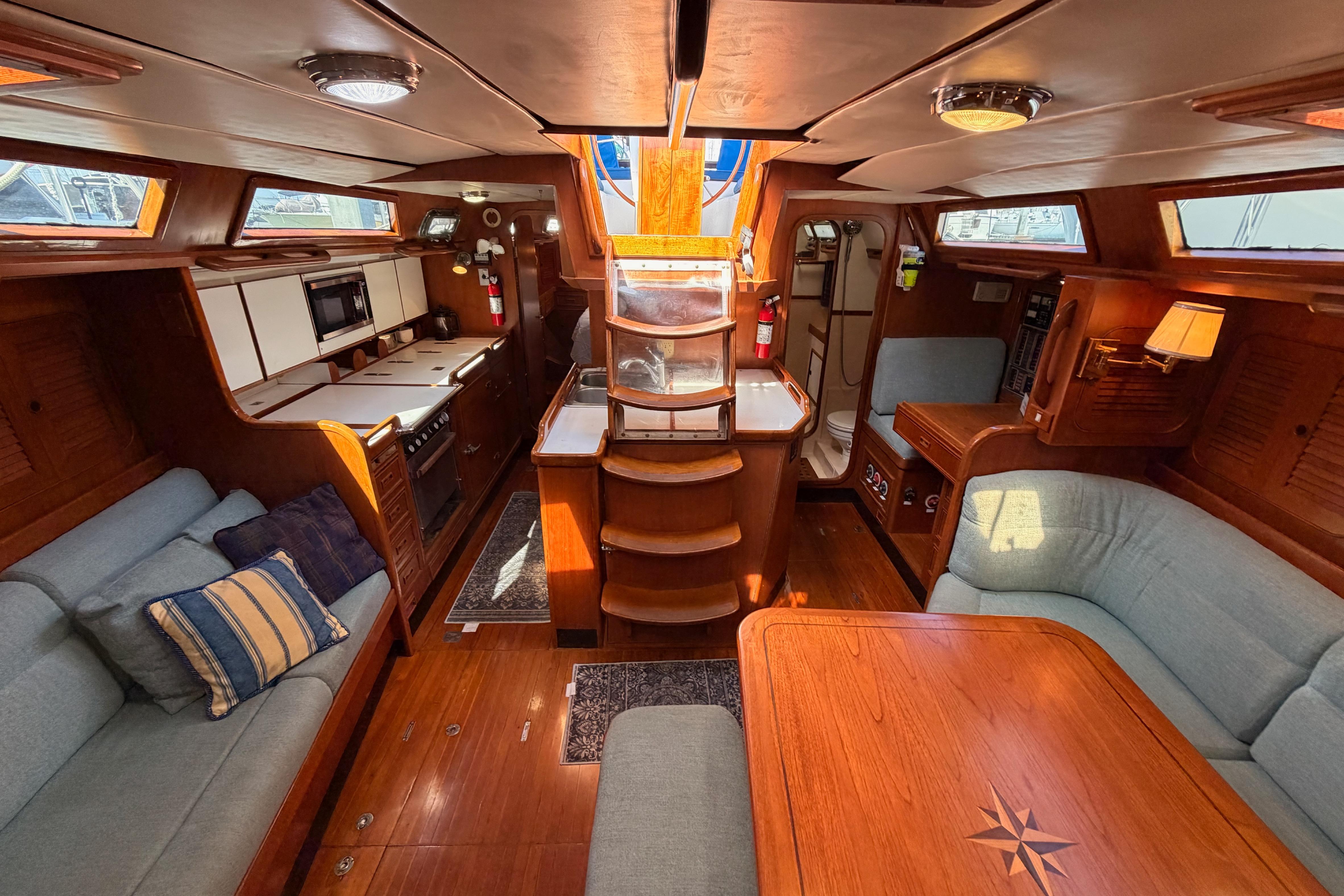 Luxurious interior of a 1991 Hylas 51 yacht with elegant wood finishes and cozy seating.