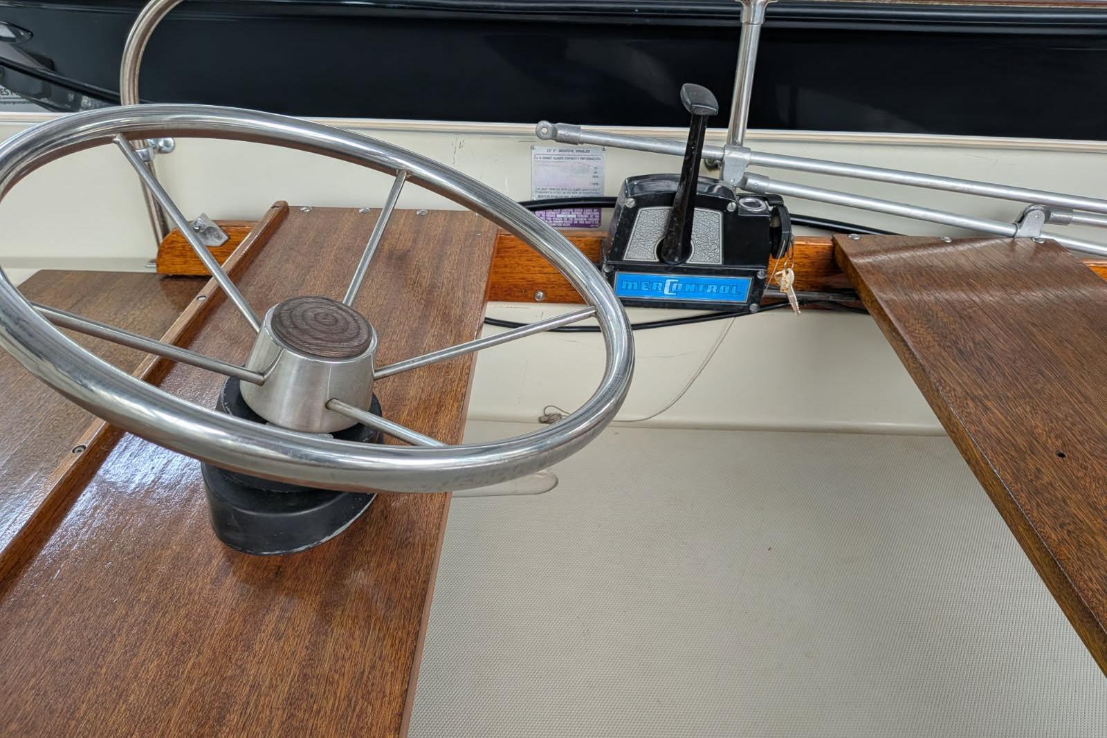 1978 Boston Whaler 15 SPORT boat steering wheel and controls, featuring wooden accents.
